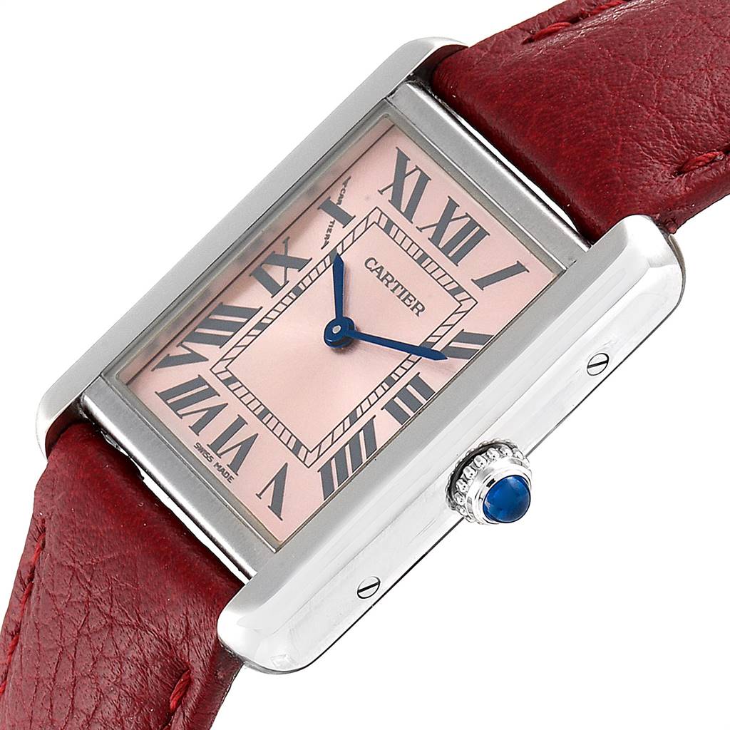 The image shows a close-up of a Cartier Tank Solo W5200000 Women's Stainless Steel Pink Dial W5200000 Women's Stainless Steel Pink Dial watch with a pink dial, blue hands, Roman numerals, and a red leather strap.