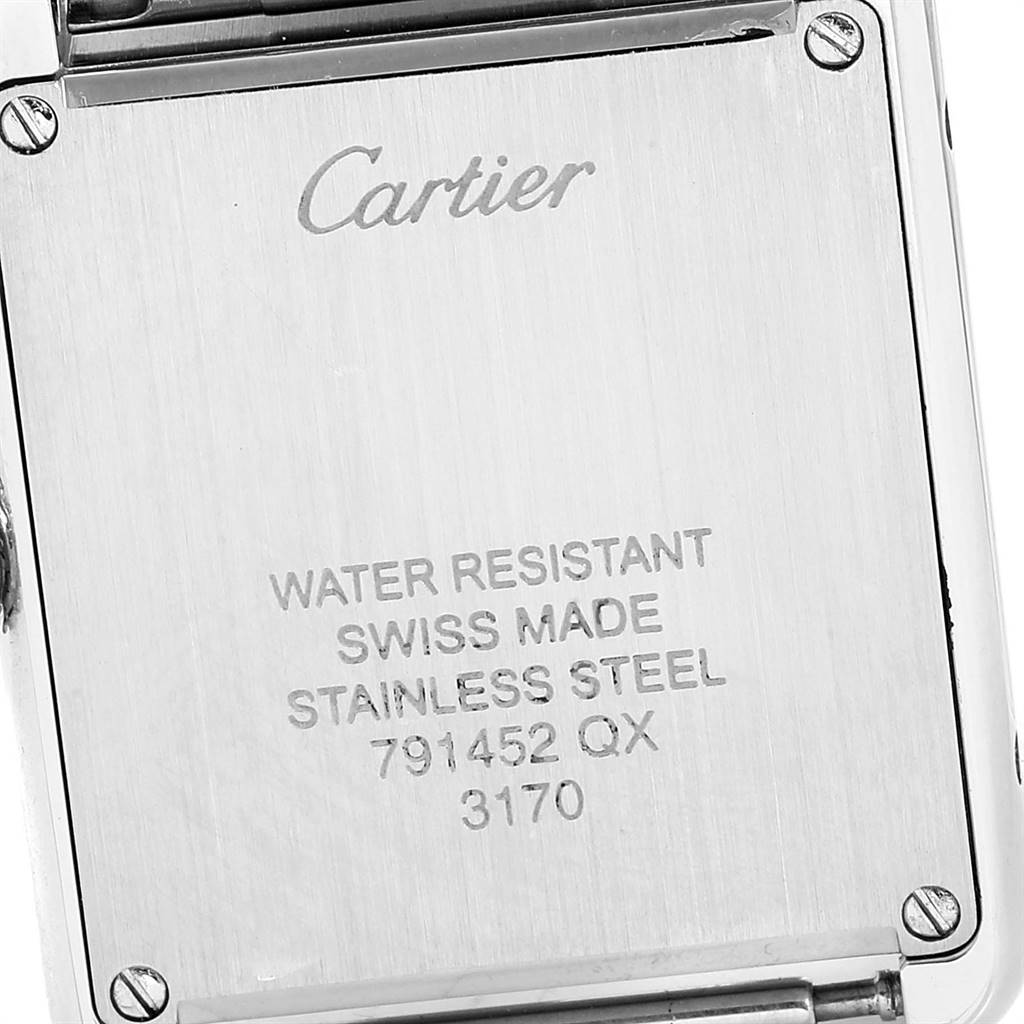 The image shows the back case of a Cartier Tank Solo W5200013 Women
s Stainless Steel Silver Dial W5200013 Women
s Stainless Steel Silver Dial watch, highlighting its inscriptions and screws.