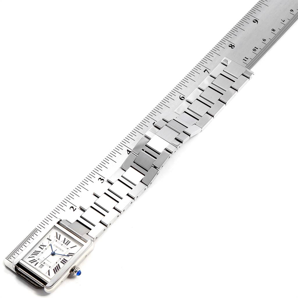 The image shows the Tank Solo Cartier watch laid flat alongside a ruler, displaying the face and metal bracelet.