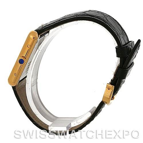 The image shows a Cartier Tank Solo W1018755 Women's Steel and Gold (two tone) Silver Dial W1018755 Women's Steel and Gold (two tone) Silver Dial watch from a side angle with a visible black leather strap and gold case, highlighting the blue cabochon crown.