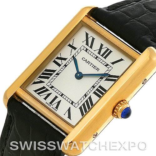 This image shows a close-up of the Cartier Tank Solo W1018755 Women's Steel and Gold (two tone) Silver Dial W1018755 Women's Steel and Gold (two tone) Silver Dial watch, highlighting its rectangular face, Roman numerals, golden casing, and black leather strap.