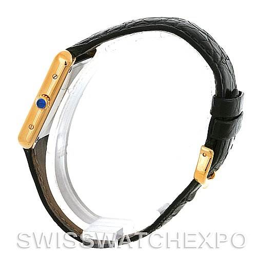 The image shows the Cartier Tank Solo W1018755 Women
s Steel and Gold (two tone) Silver Dial W1018755 Women
s Steel and Gold (two tone) Silver Dial model watch from a side angle, highlighting its gold casing, blue cabochon crown, and black leather strap.