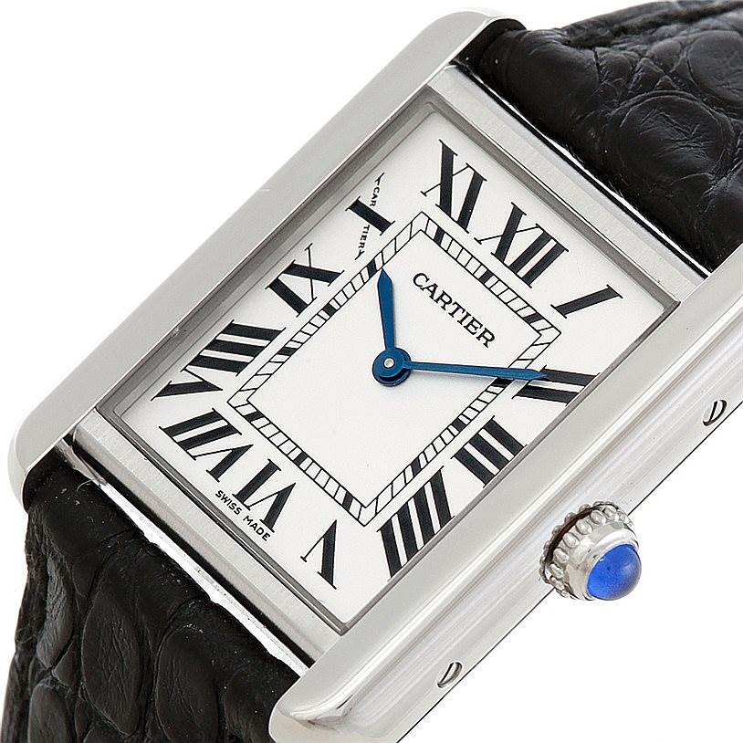 The Cartier Tank Solo W1018255 Women's Stainless Steel Silver Dial W1018255 Women's Stainless Steel Silver Dial watch is shown at an angled view, highlighting its face, blue hands, Roman numerals, and crown with a blue cabochon.