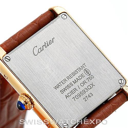 This image shows the back case of a Cartier Tank Solo W1018755 Women's Steel and Gold (two tone) Silver Dial W1018755 Women's Steel and Gold (two tone) Silver Dial watch, highlighting its engravings and the brown leather strap attachment.