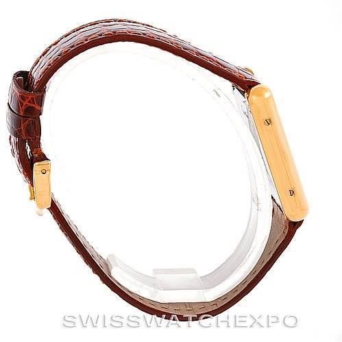 The image shows a side view of a Tank Solo model by Cartier, highlighting the golden case and brown leather strap.