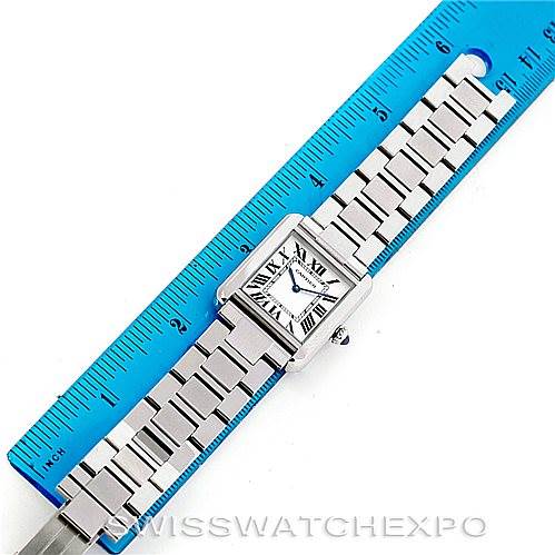 The image shows a top view of the Cartier Tank Solo W5200013 Women's Stainless Steel Silver Dial W5200013 Women's Stainless Steel Silver Dial watch with a metal bracelet, next to a blue ruler for size reference.