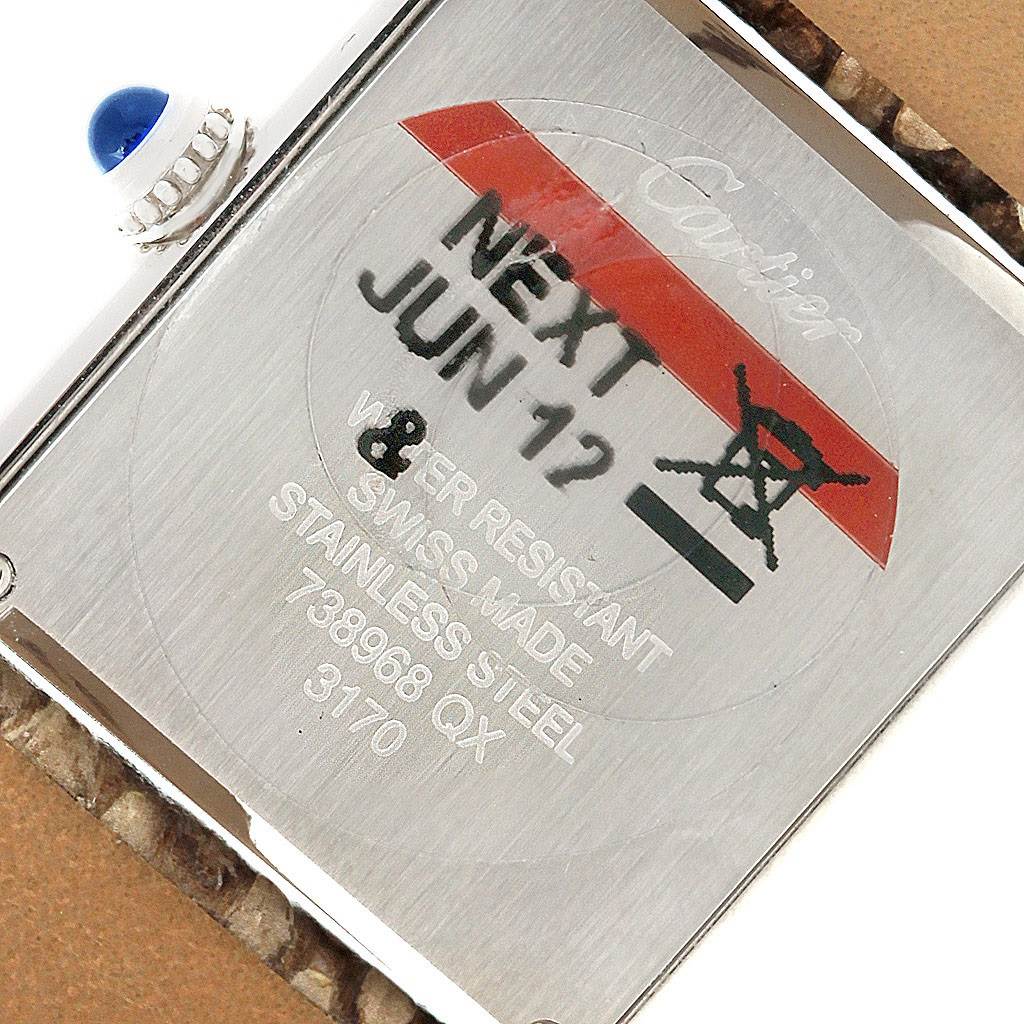 The image shows the back case and crown of the Cartier Tank Solo W5200020 Women's Stainless Steel Blue Dial W5200020 Women's Stainless Steel Blue Dial watch with a protective sticker on it.