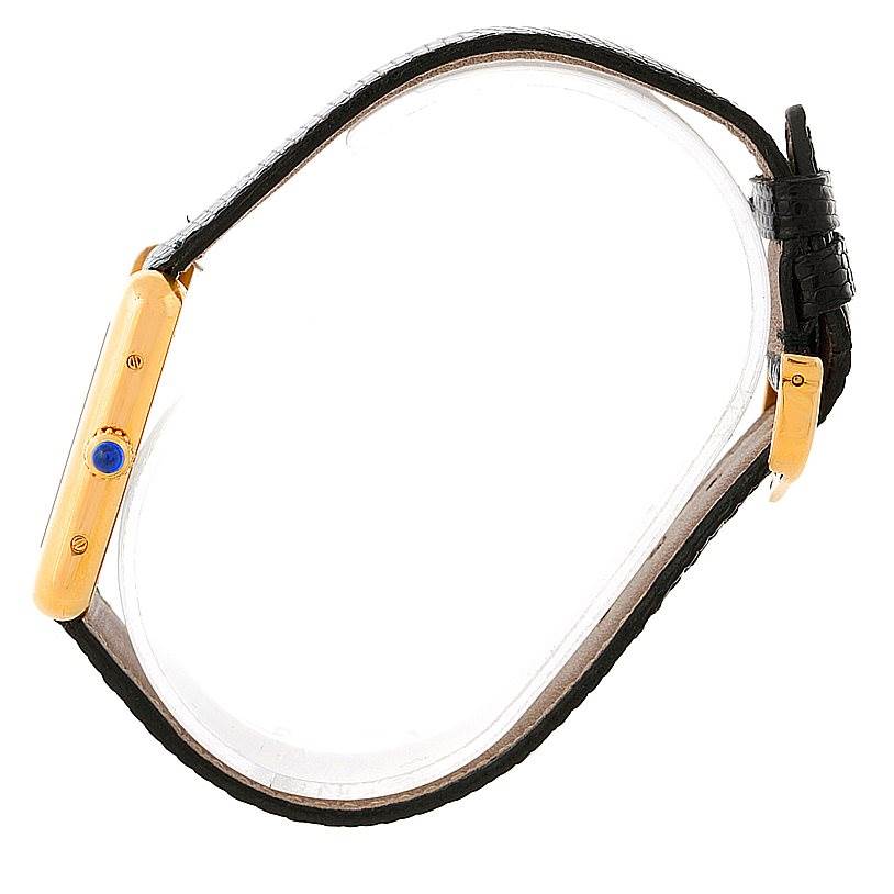 The image shows a side angle of a Cartier Tank Solo W1018755 Women's Steel and Gold (two tone) Silver Dial W1018755 Women's Steel and Gold (two tone) Silver Dial watch, highlighting the gold case, crown with a blue cabochon, and black leather strap.