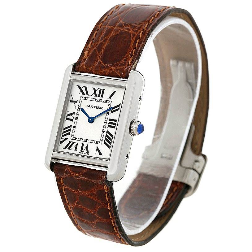 The Cartier Tank Solo W1018255 Women's Stainless Steel Silver Dial W1018255 Women's Stainless Steel Silver Dial watch is shown at an angle displaying its face, Roman numerals, crown, and brown leather strap.