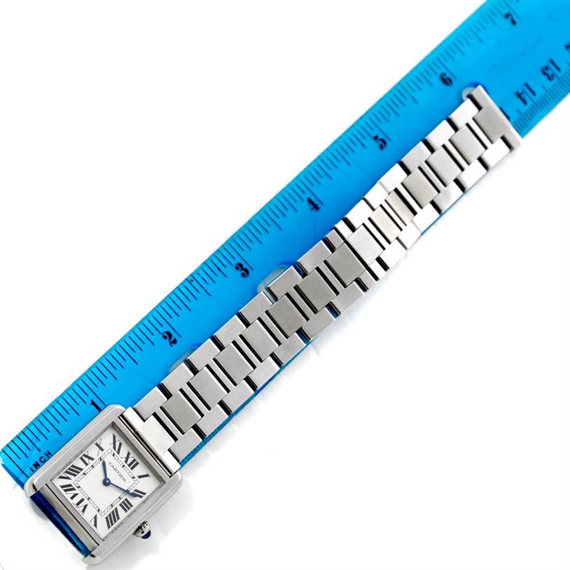 The Cartier Tank Solo W5200013 Women's Stainless Steel Silver Dial W5200013 Women's Stainless Steel Silver Dial watch is shown lying flat alongside a ruler, displaying the face and metal bracelet.