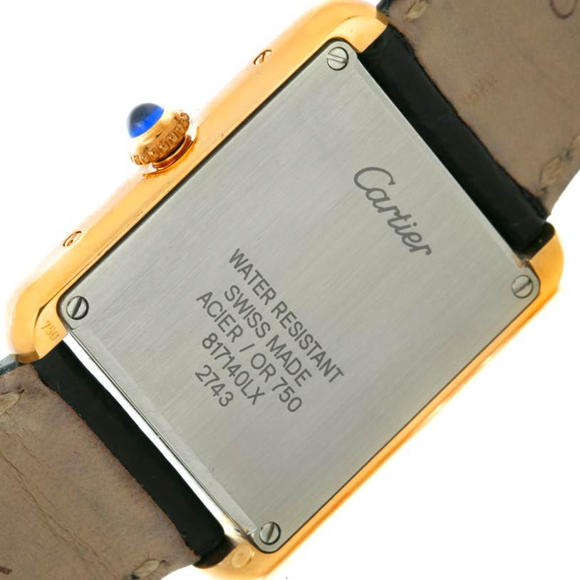 The image shows the back view of the Cartier Tank Solo W1018755 Women's Steel and Gold (two tone) Silver Dial W1018755 Women's Steel and Gold (two tone) Silver Dial watch, highlighting the caseback with inscriptions and the crown with a blue cabochon.