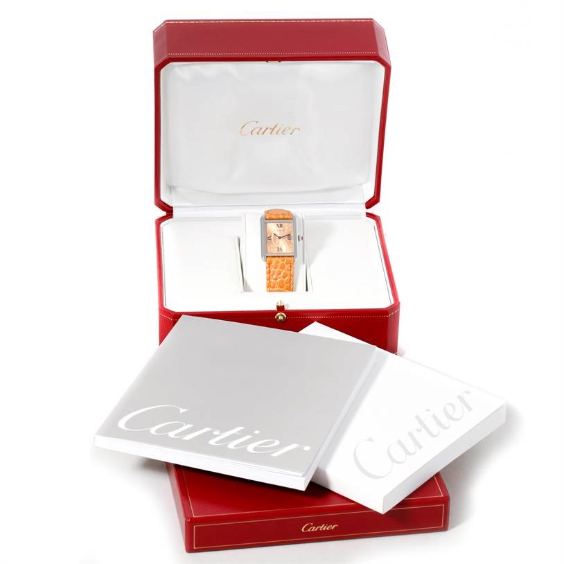The Cartier Tank Solo W1019455 Women's Stainless Steel Orange Dial W1019455 Women's Stainless Steel Orange Dial watch is shown in its open red box with accompanying booklets.