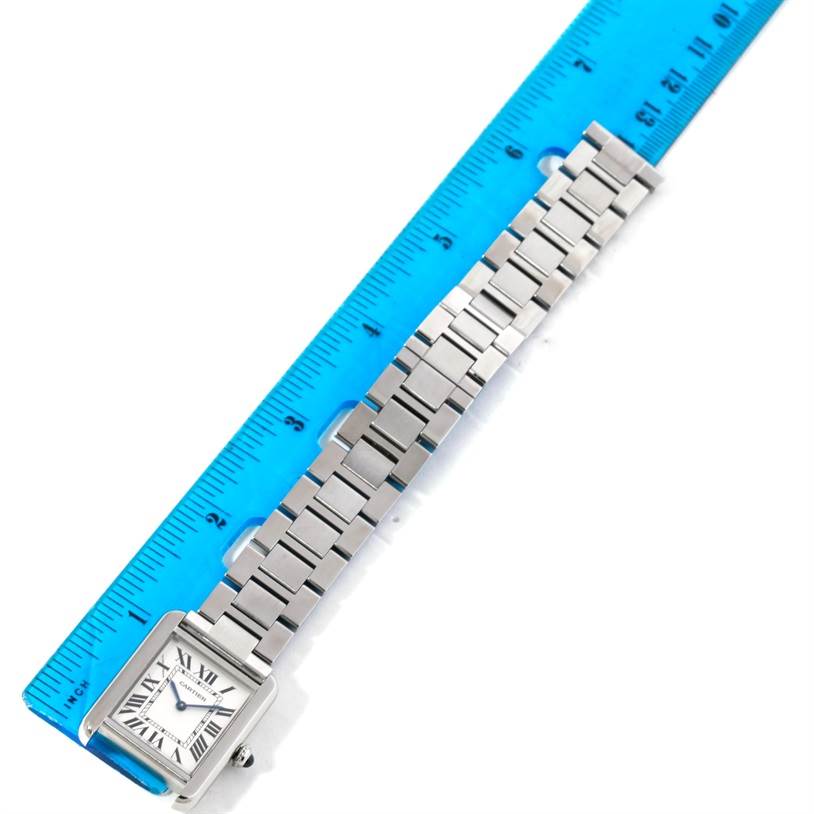 The image shows a top-view angle of a Cartier Tank Solo W5200013 Women's Stainless Steel Silver Dial W5200013 Women's Stainless Steel Silver Dial watch, featuring its face and metal bracelet next to a ruler.