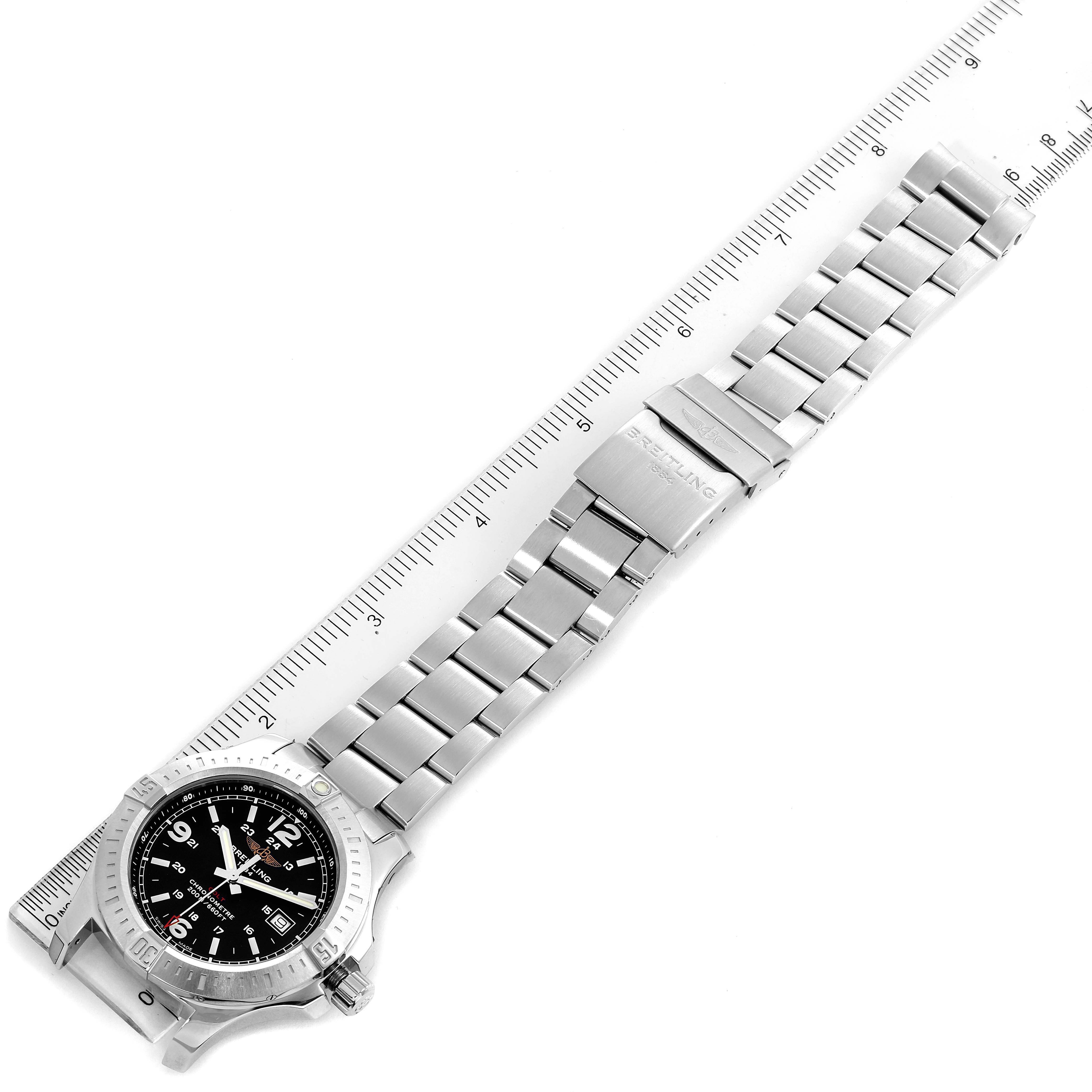 The image shows an aerial view of the Breitling Colt A74388 Men's Stainless Steel Black Dial A74388 Men's Stainless Steel Black Dial watch, displaying its face, bezel, and metal bracelet alongside a ruler for measurement.