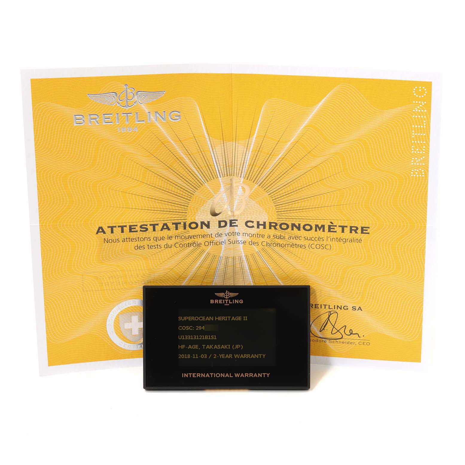 The image shows the Breitling certification and warranty card for the Superocean model, with the card in front of the certificate.