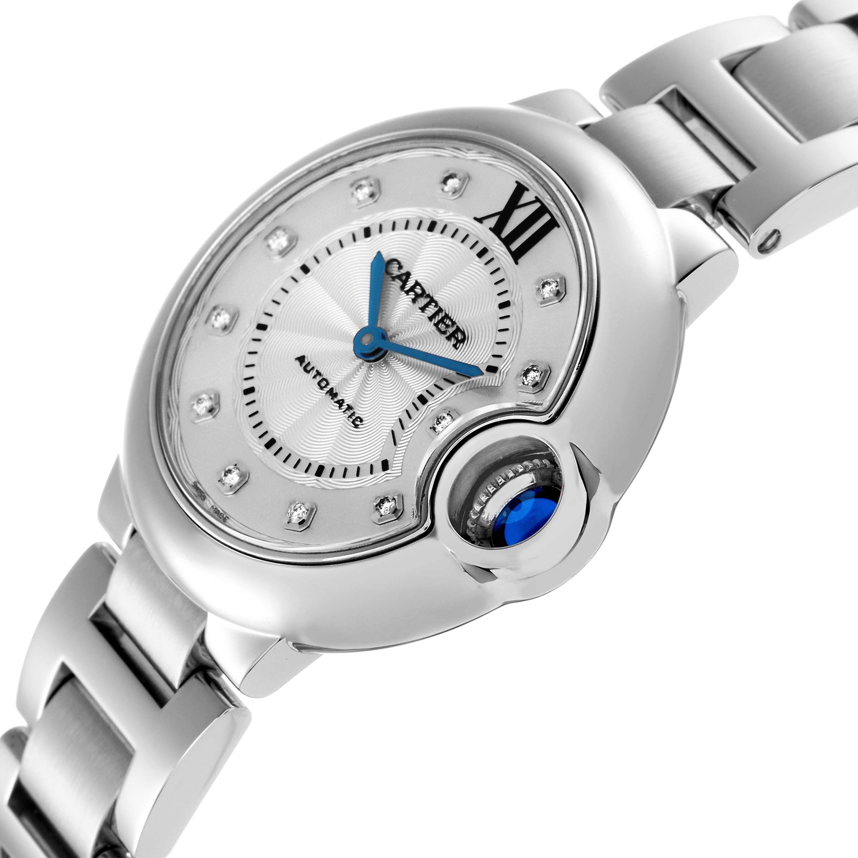 The Cartier Ballon Bleu WE902074 Women
s Stainless Steel Silver Dial WE902074 Women
s Stainless Steel Silver Dial watch is shown at a tilted angle, highlighting its silver dial, blue hands, and signature sapphire cabochon crown.