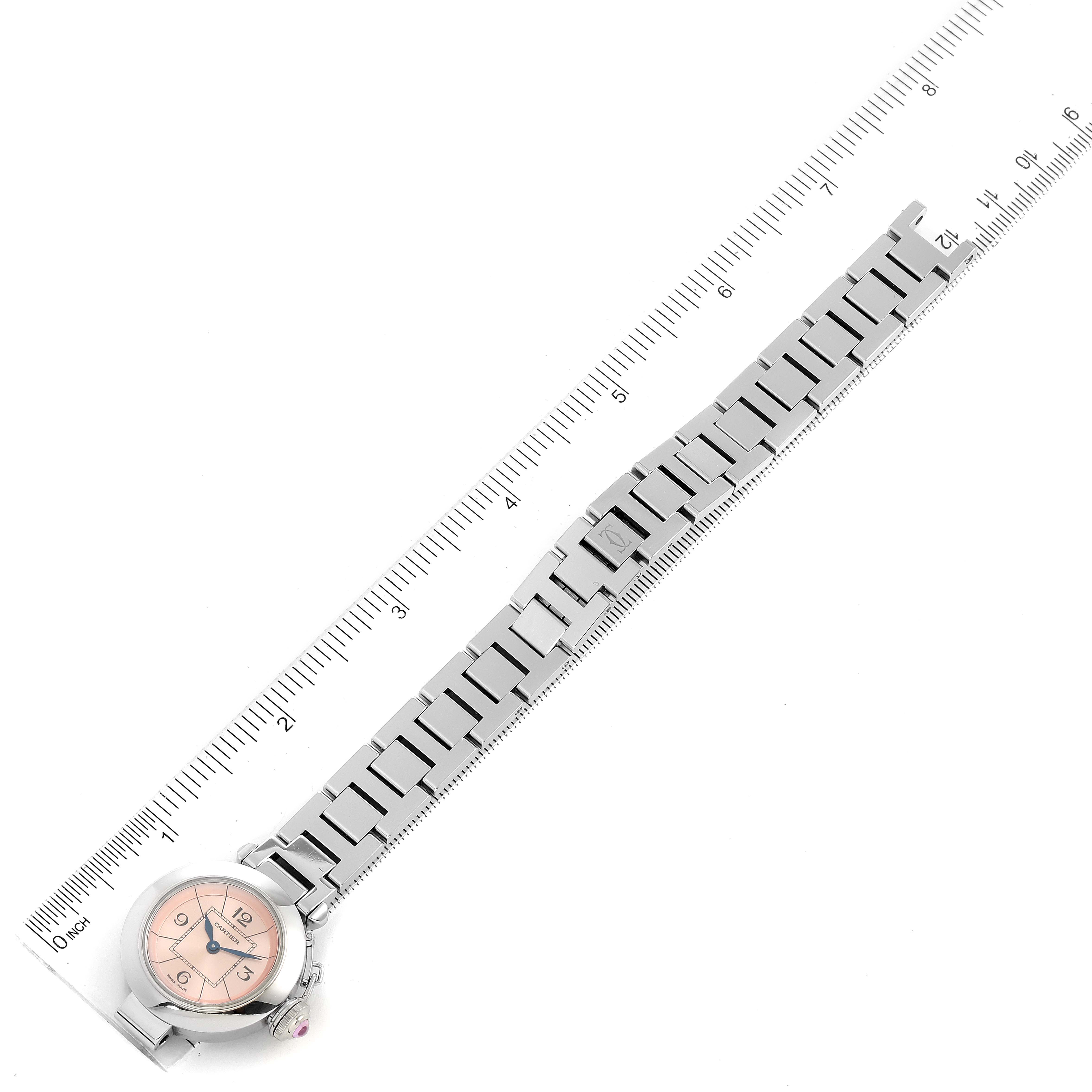The image shows a full view of the Cartier Pasha W3140008 Women's Stainless Steel Pink Dial W3140008 Women's Stainless Steel Pink Dial watch laid alongside a ruler, highlighting both the watch face and the metal bracelet.