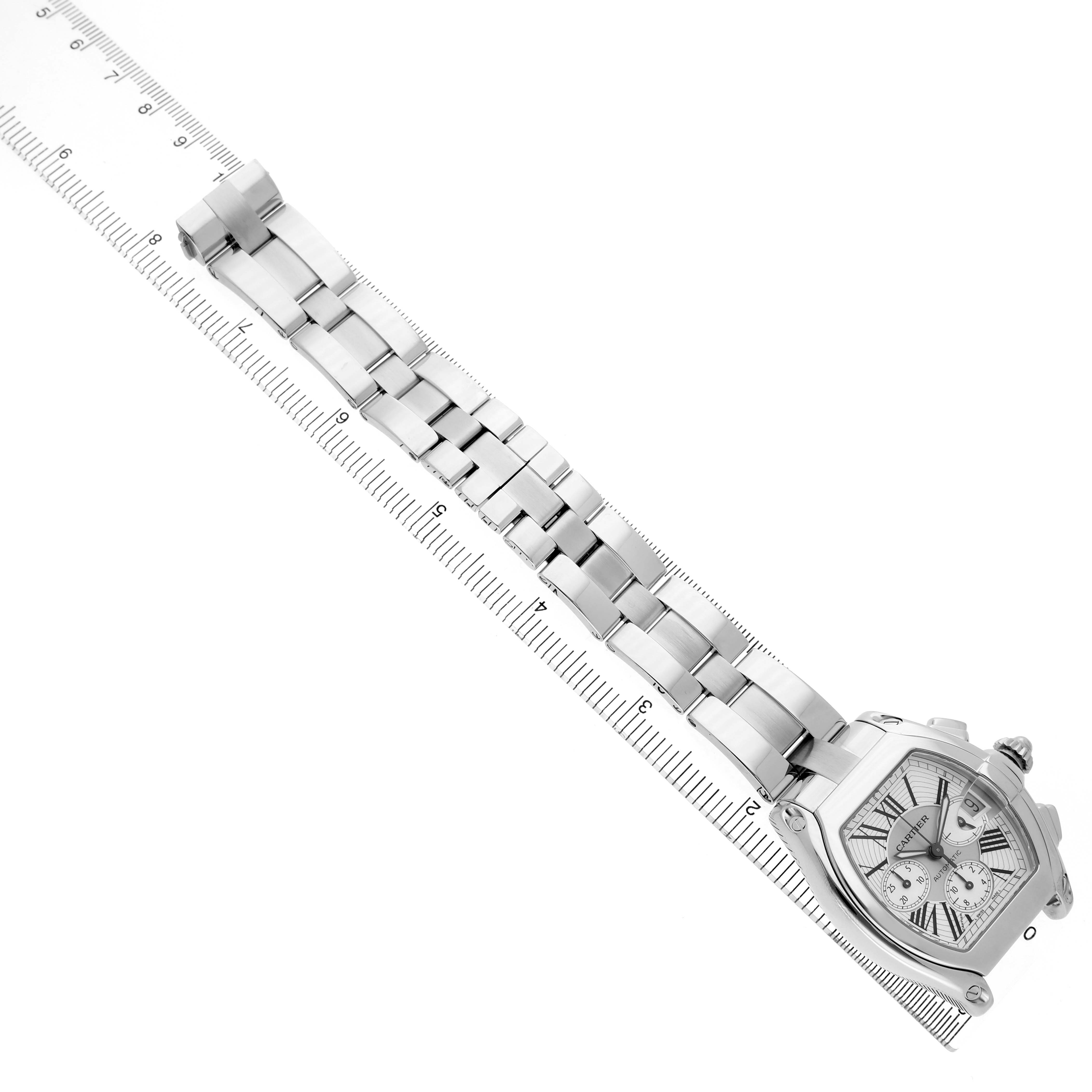 The image shows a Cartier Roadster W62019X6 Men's Stainless Steel Silver Dial watch at a diagonal angle, highlighting the bracelet and face with a ruler for scale.