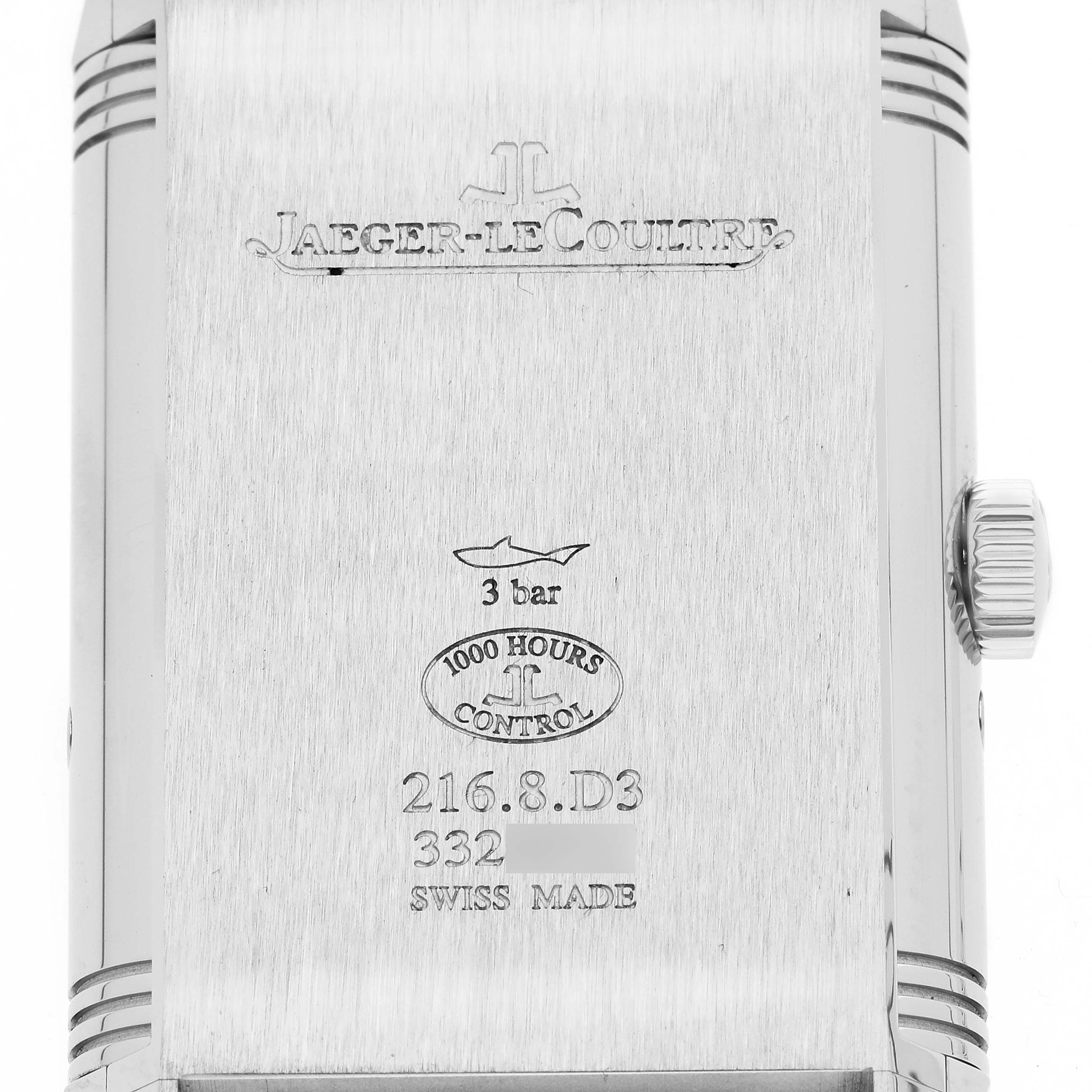 The image shows the back of a Jaeger-LeCoultre Reverso watch, featuring engravings, the crown, and side detailing.