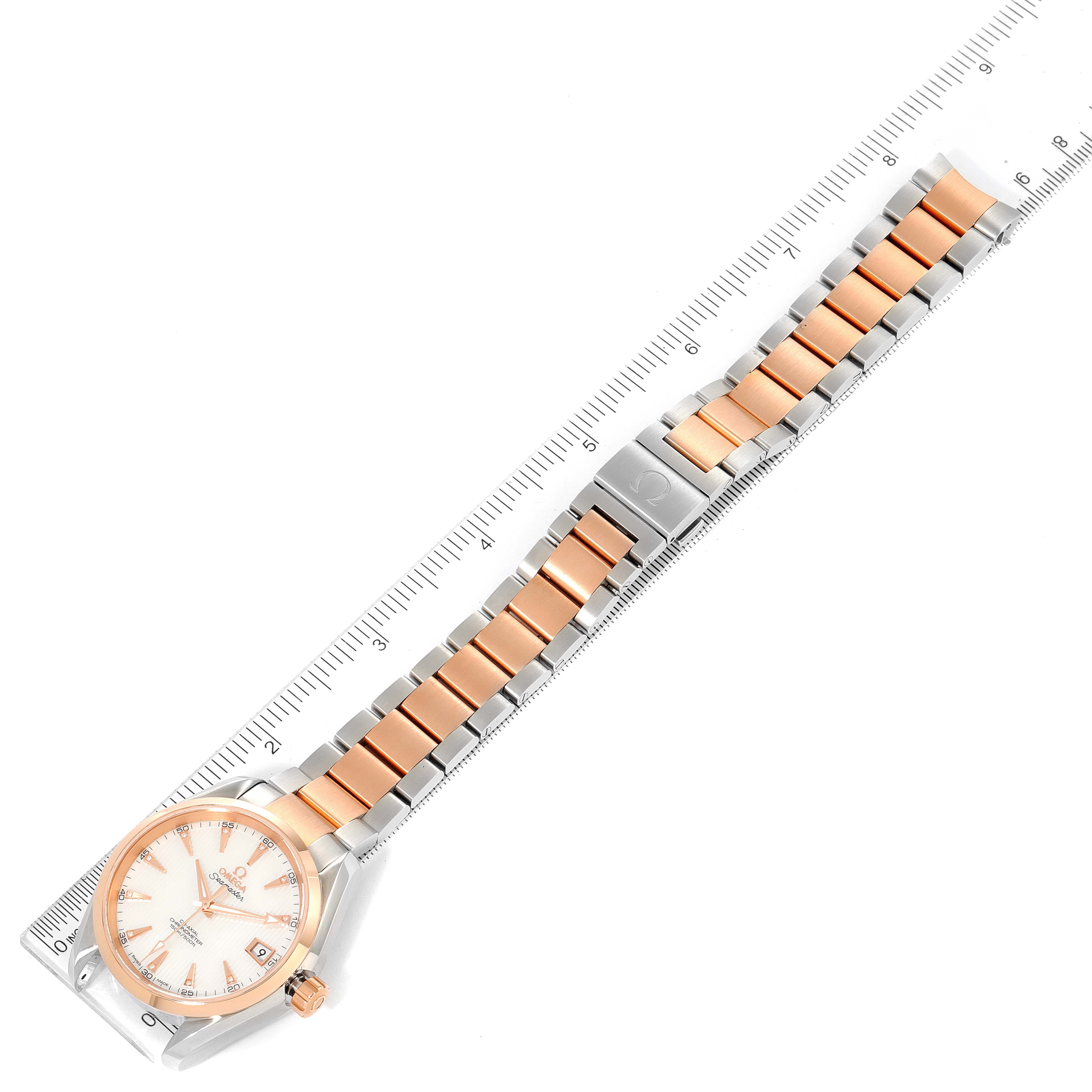 The image shows an Omega Aqua Terra 231.20.39.21.55.001 Men's Steel and Gold (two tone) Mother of Pearl Dial 231.20.39.21.55.001 Men's Steel and Gold (two tone) Mother of Pearl Dial watch positioned horizontally against a ruler, displaying its face and two-tone band.