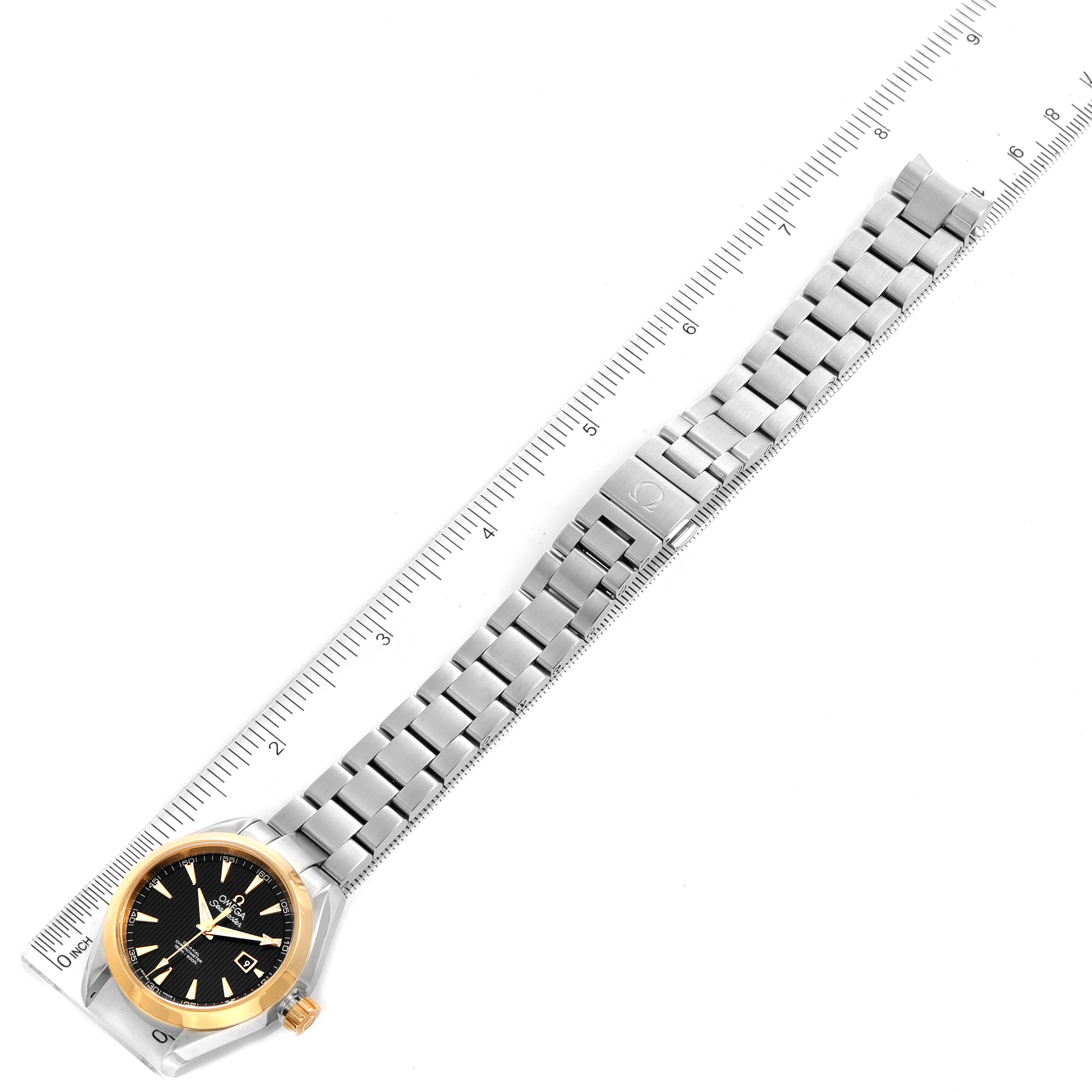 The image shows the Omega 231.20.34.20.01.004 Women's Steel and Gold (two tone) Black Dial 231.20.34.20.01.004 Women's Steel and Gold (two tone) Black Dial Seamaster Aqua Terra Steel Yellow Gold Watch 231.20.34.20.01.004 laid beside a ruler, focusing on the band and face.