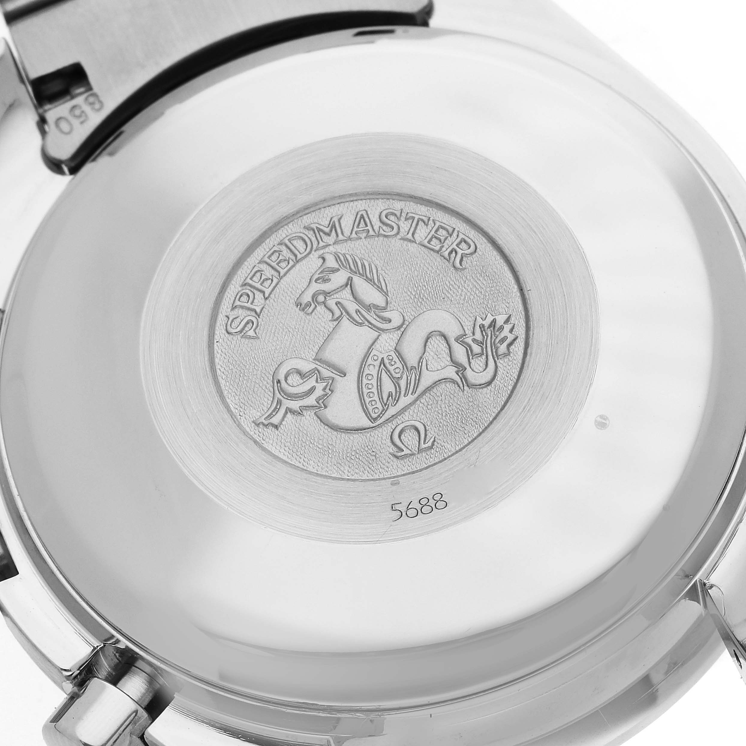 The image shows the case back of an Omega Speedmaster 3513.30.00 Men
s Stainless Steel Silver Dial 3513.30.00 Men
s Stainless Steel Silver Dial watch, displaying its engraved emblem and partial view of the bracelet clasp.