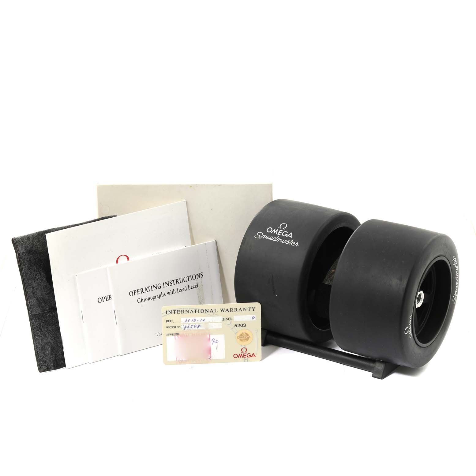 The image shows Omega Speedmaster 3510.12.00 Men's Stainless Steel Yellow Dial 3510.12.00 Men's Stainless Steel Yellow Dial accessories including a tire-shaped case, operating instructions, and an international warranty card.