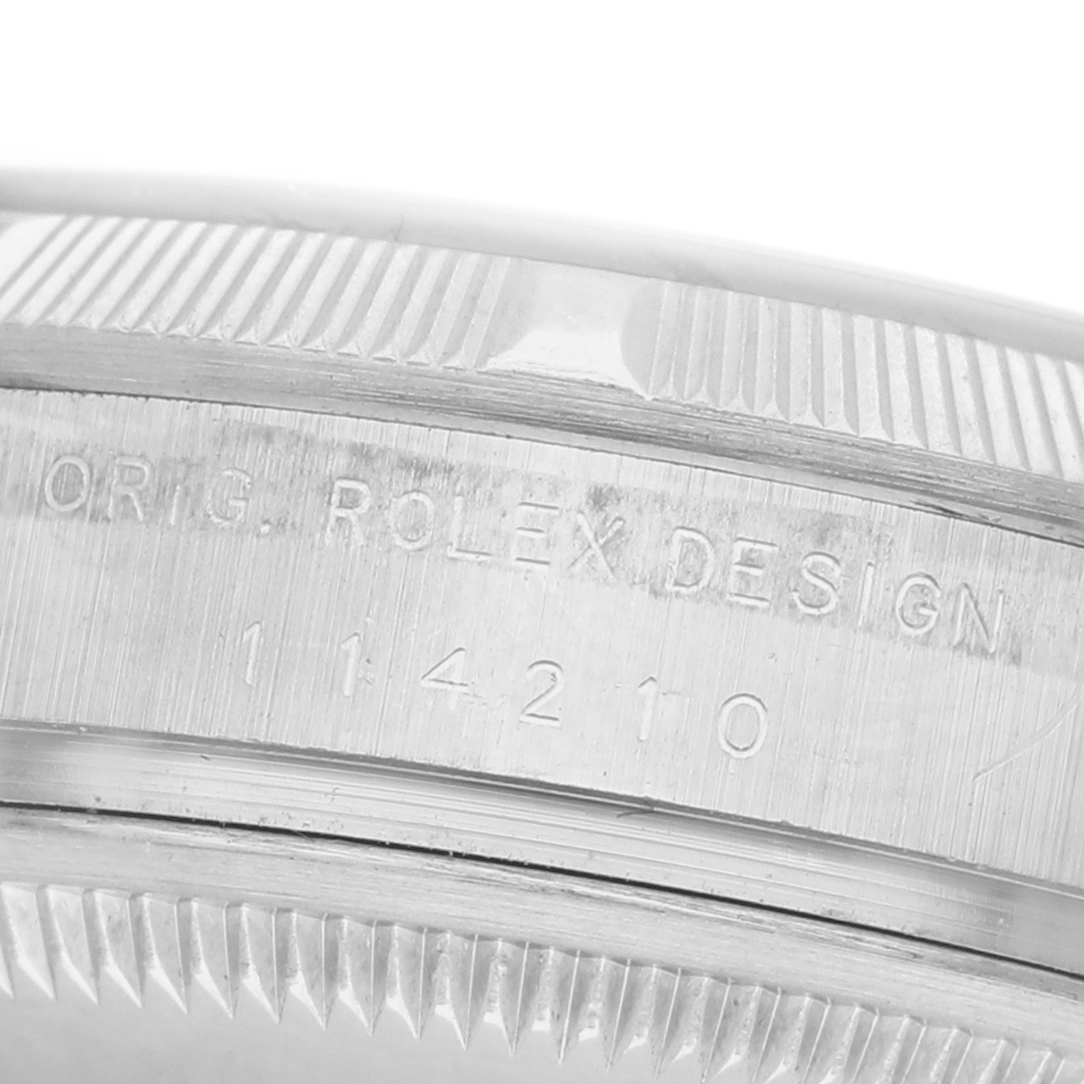 The image shows a close-up of the side of the Rolex Air-King 114210 Men's Stainless Steel Silver Dial watch, highlighting the engraved model number and design details.