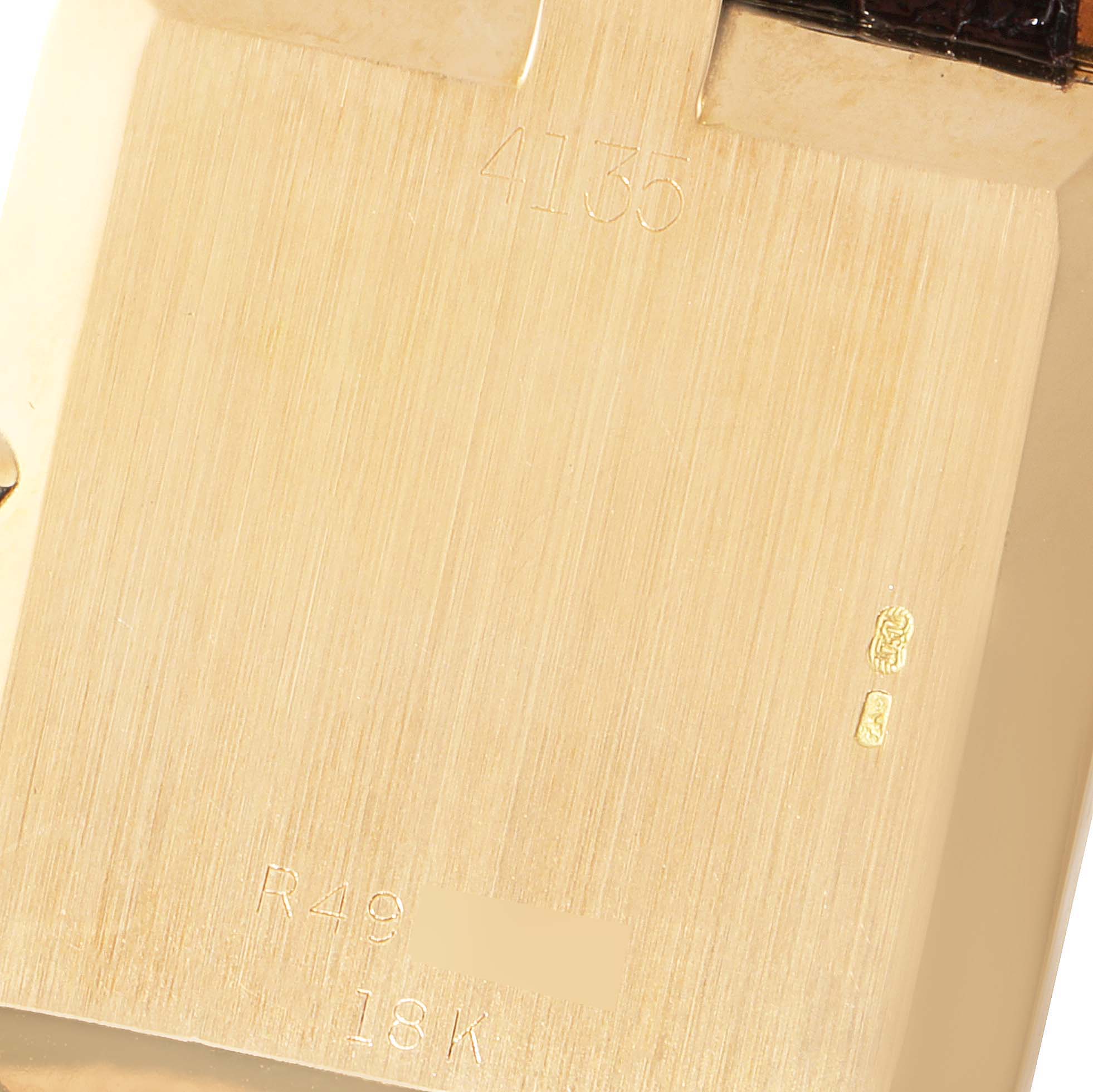 This is a close-up image of the back case of a Rolex Cellini 4135 Men's Yellow Gold Champagne Dial 4135 Men's Yellow Gold Champagne Dial model, showing engravings and hallmarks.