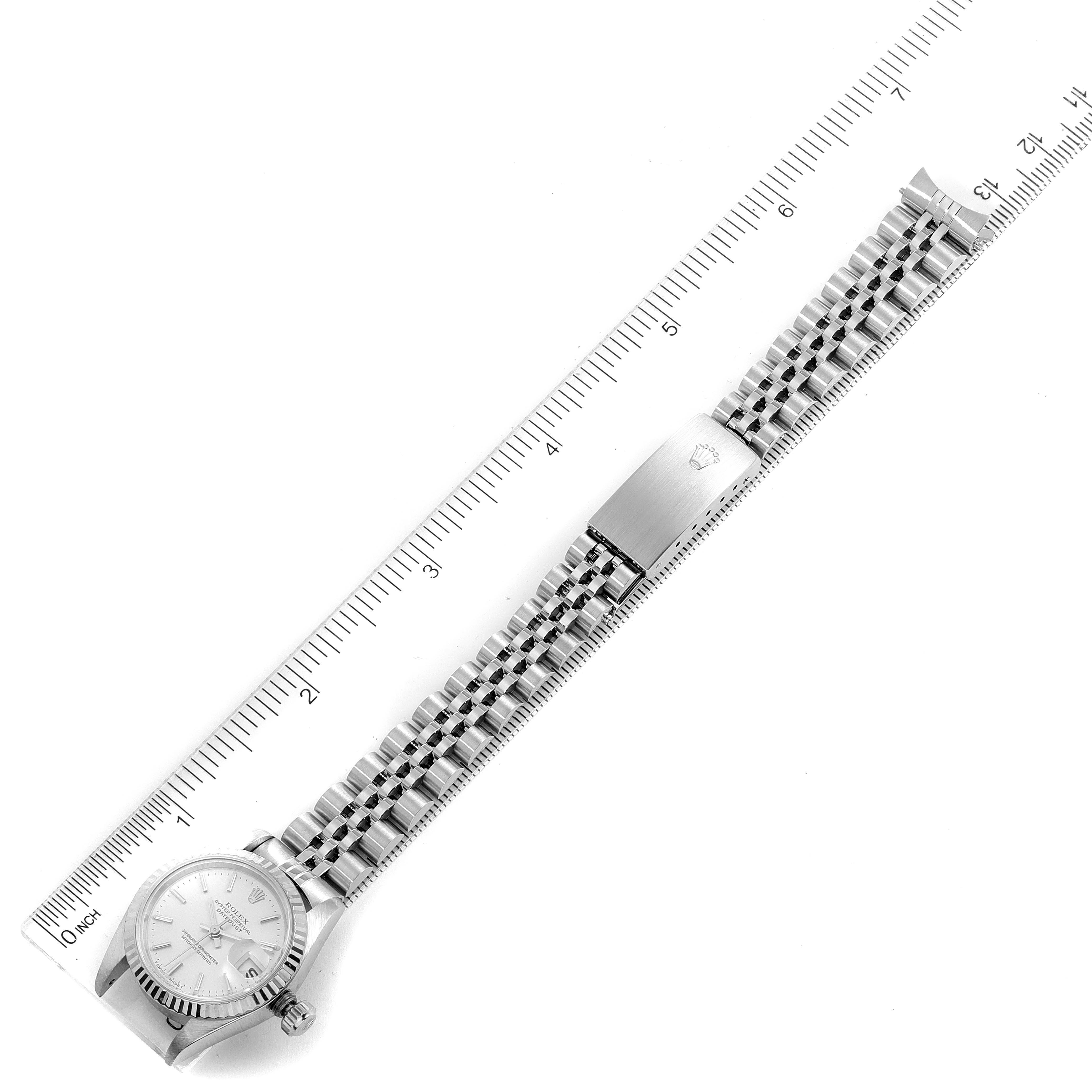 The image shows a Rolex Datejust 79174 Women
s Stainless Steel Silver Dial 79174 Women
s Stainless Steel Silver Dial watch laid flat along a ruler, displaying the watch face, bracelet, and clasp.