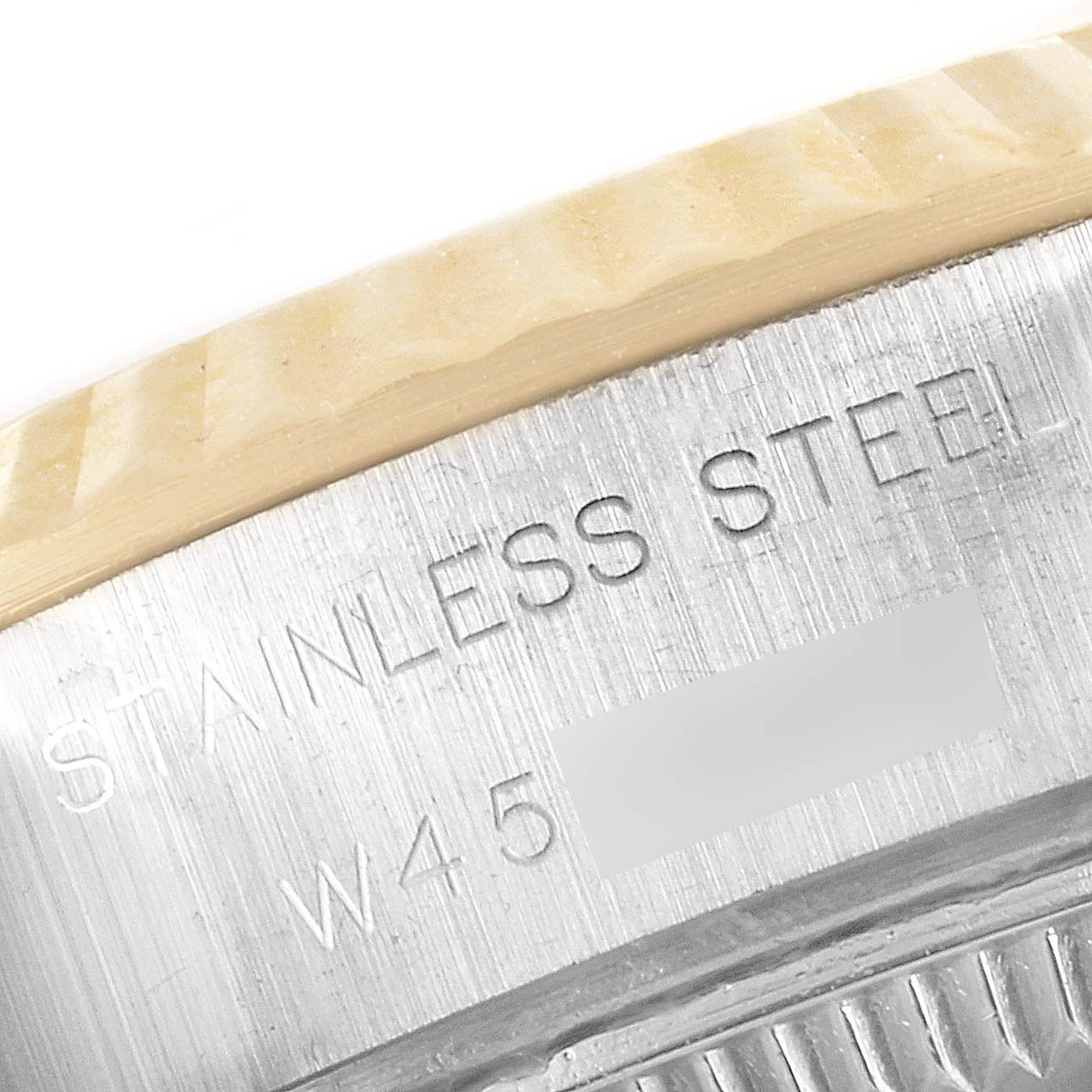 This is a close-up view showing the "STAINLESS STEEL" engraving on a Rolex Datejust 69173 Women
s Steel and Gold (two tone) Champagne Dial 69173 Women
s Steel and Gold (two tone) Champagne Dial watch
s case.