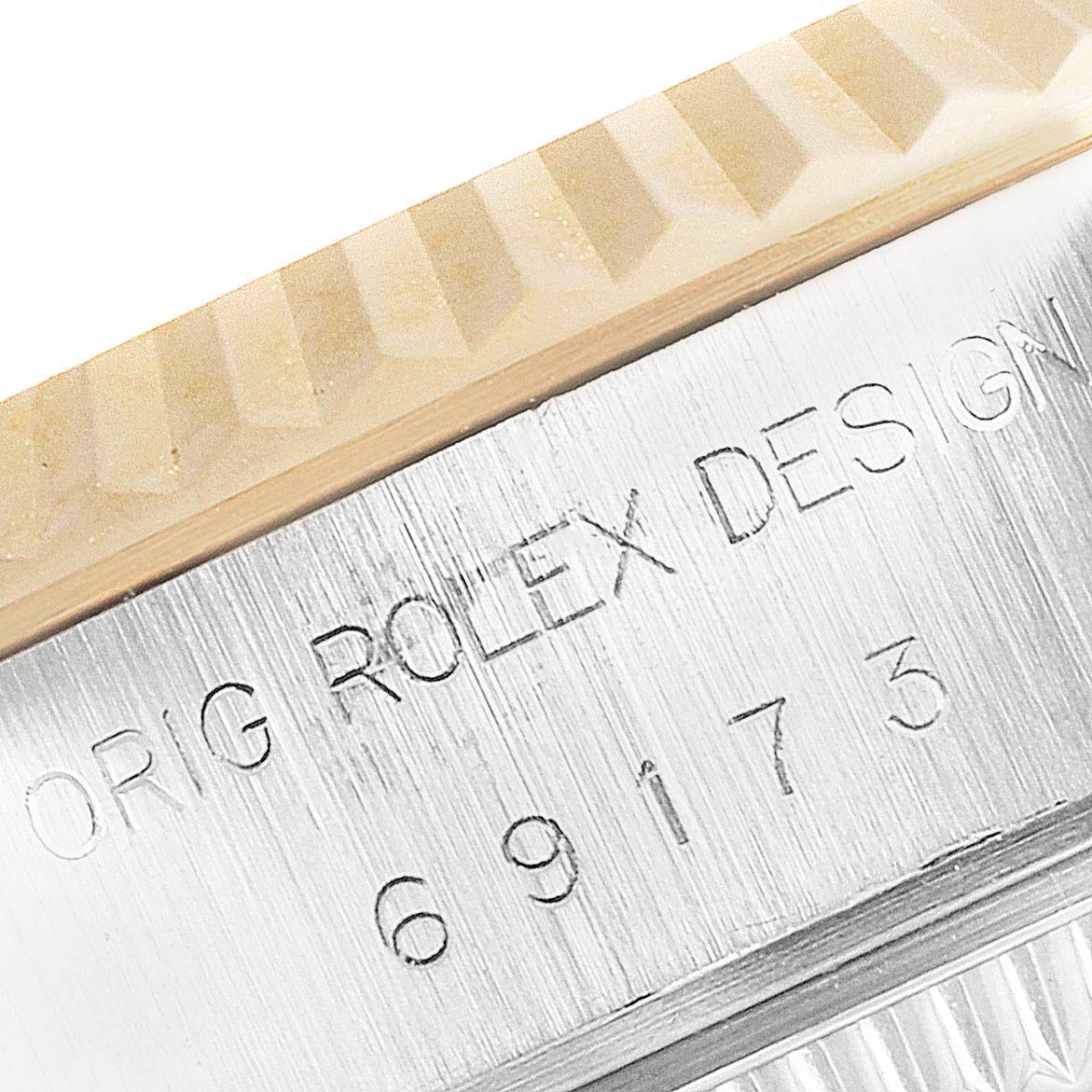 This close-up image of a Rolex Datejust 69173 Women
s Steel and Gold (two tone) Champagne Dial 69173 Women
s Steel and Gold (two tone) Champagne Dial shows the edge of the bezel and part of the engraved watch case.