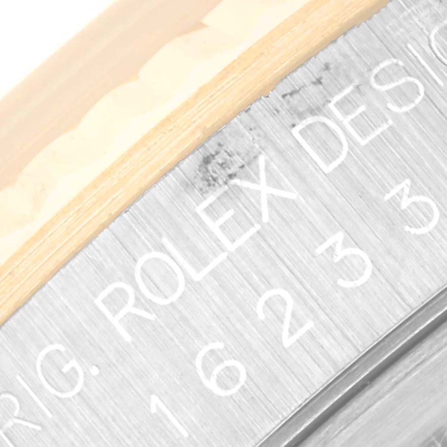 The image shows a close-up of the side of the Rolex Datejust 16233 Men's Steel and Gold (two tone) Champagne Dial 16233 Men's Steel and Gold (two tone) Champagne Dial watch case with engraved text.