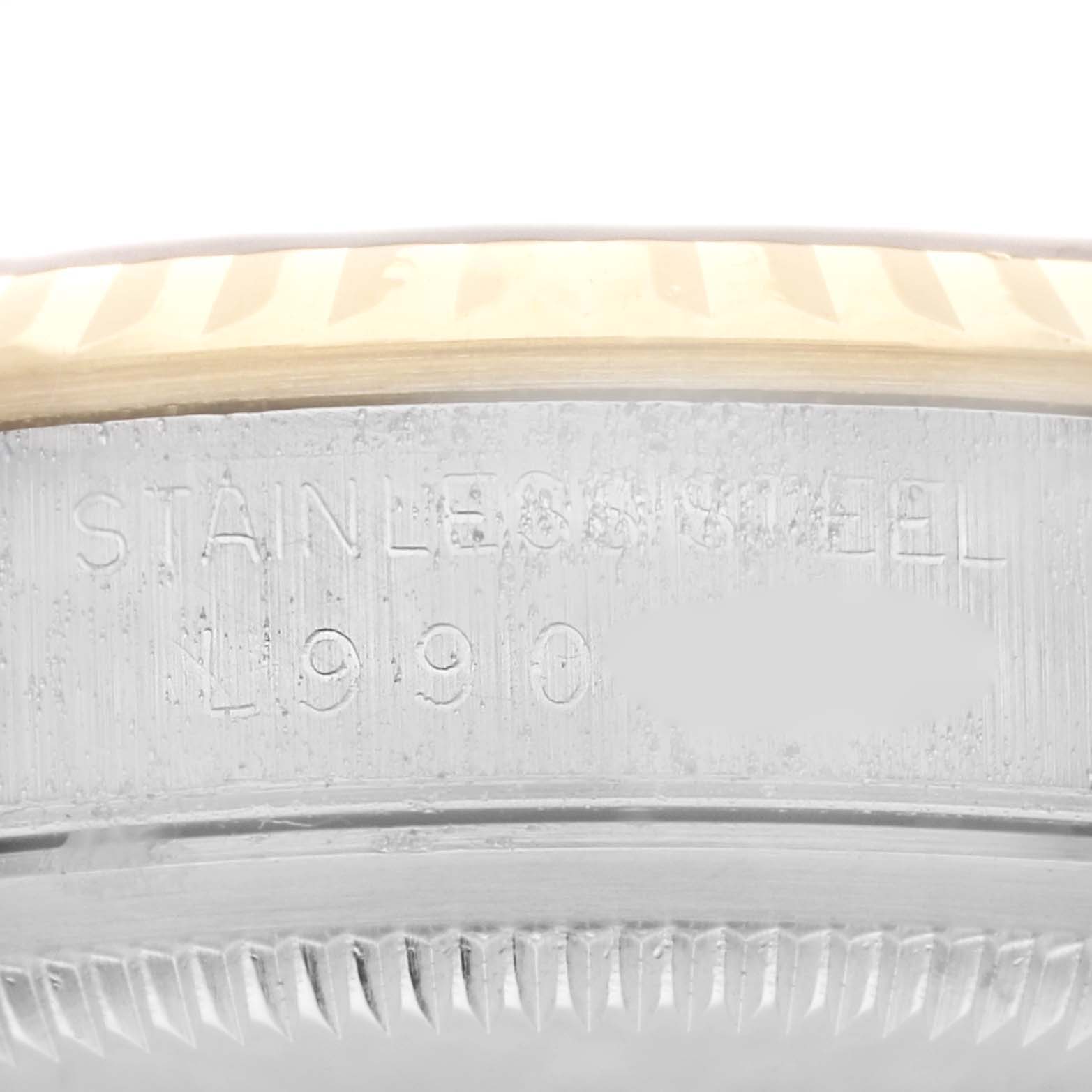 This image shows a close-up view of the case side and bezel of a Rolex Datejust 16233 Men's Steel and Gold (two tone) Champagne Dial 16233 Men's Steel and Gold (two tone) Champagne Dial, highlighting the serial number engraving and bezel fluting.