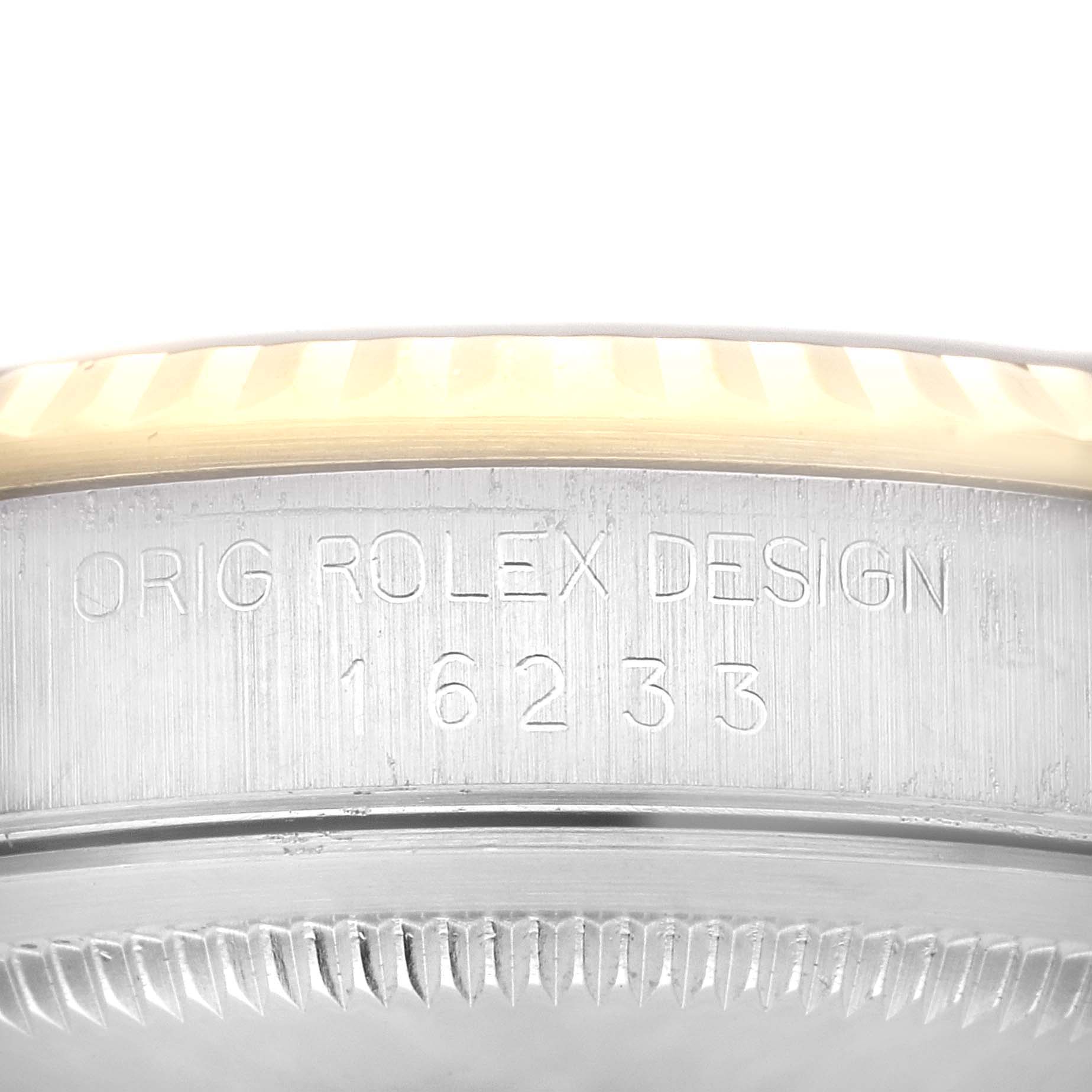 This image shows a close-up of the sideview of a Rolex Datejust 16233 Men's Steel and Gold (two tone) Champagne Dial 16233 Men's Steel and Gold (two tone) Champagne Dial watch, highlighting the engravings and part of the bezel.