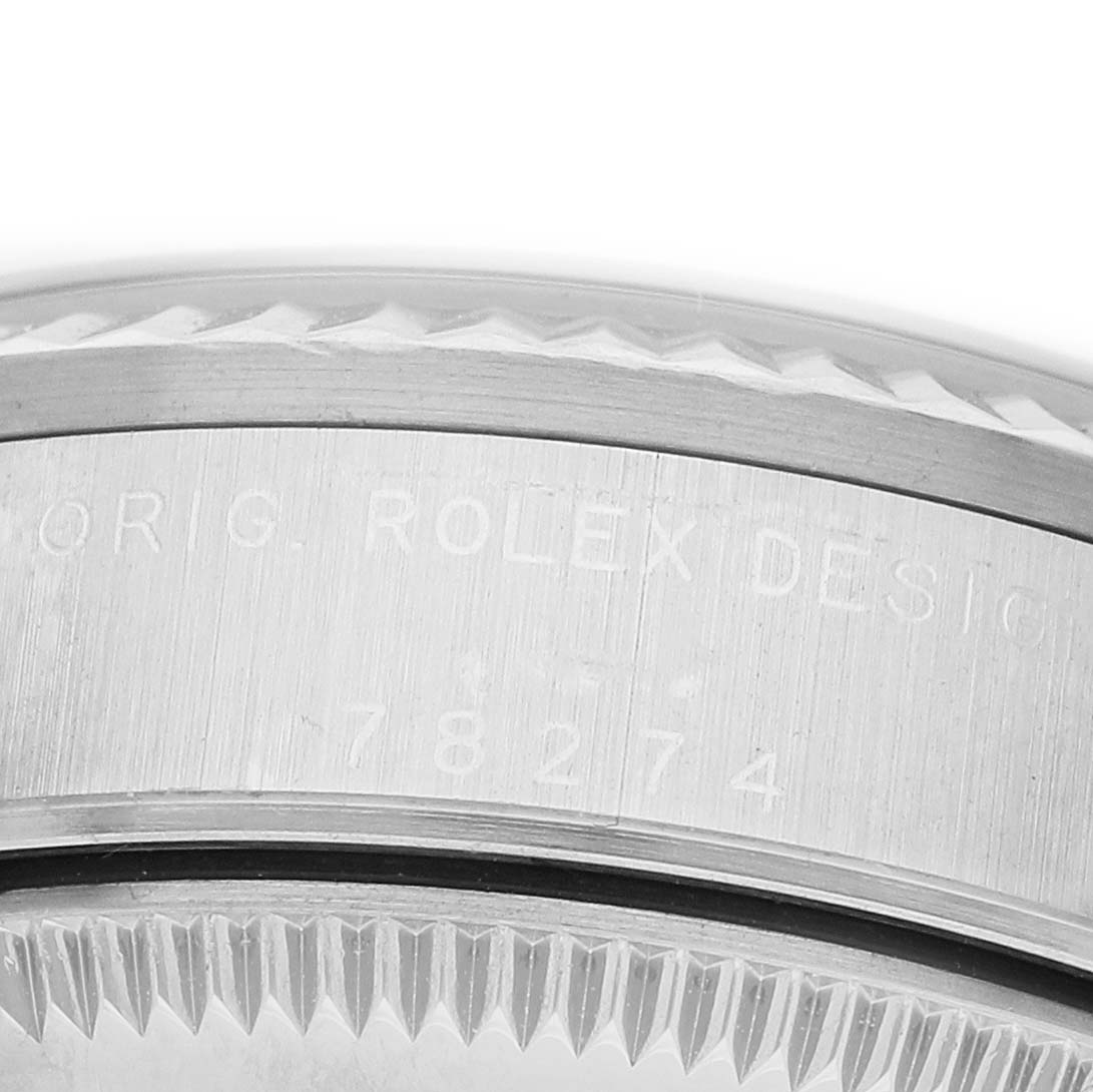 The image shows a close-up view of the case side and bezel of a Rolex Datejust 78274 Men's Stainless Steel Black Dial, featuring engraved text and a fluted bezel.