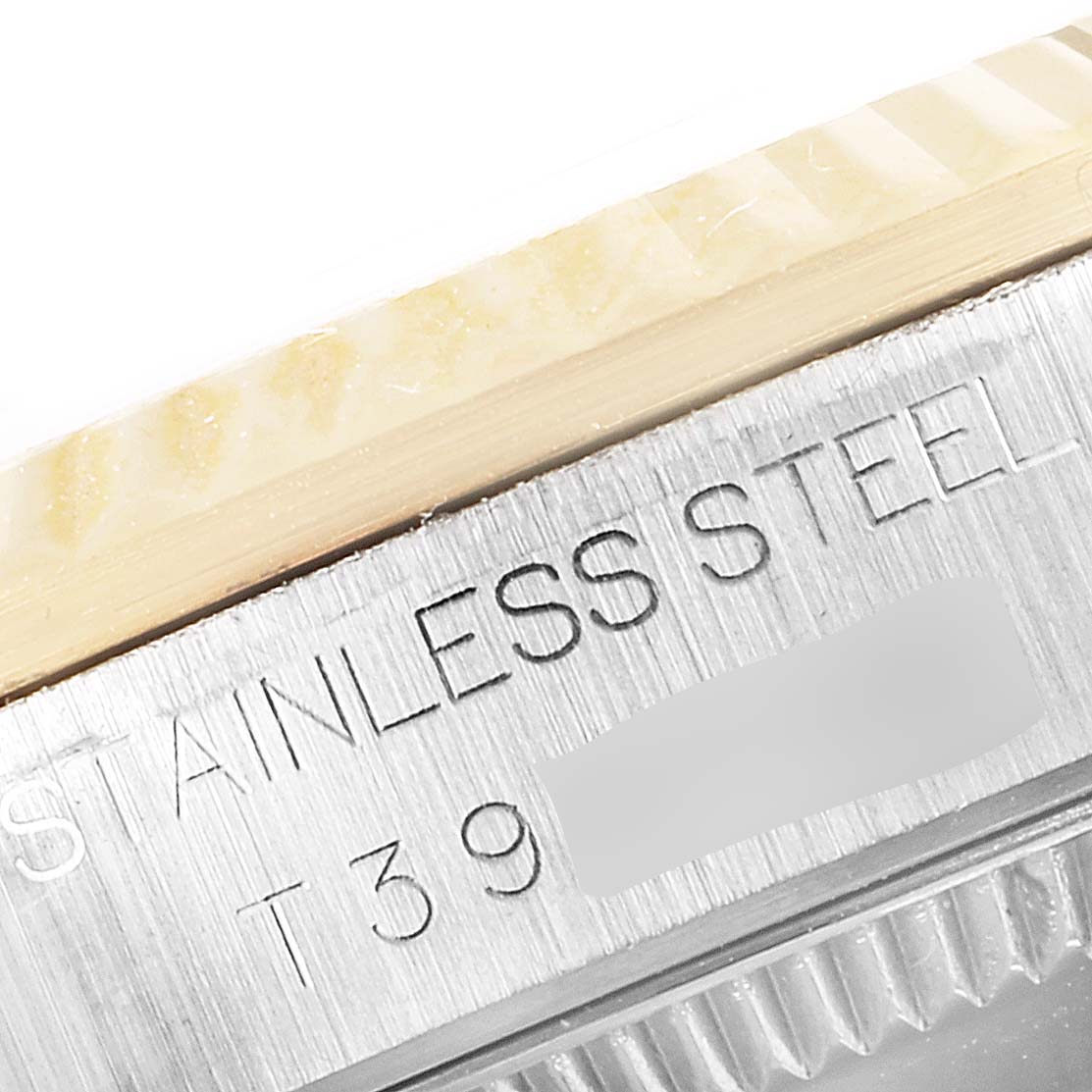 A close-up angle of a Rolex Mid-Size 68273 Women's Steel and Gold (two tone) Champagne Dial 68273 Women's Steel and Gold (two tone) Champagne Dial watch, showing the edge of the bezel with "STAINLESS STEEL" engraved.