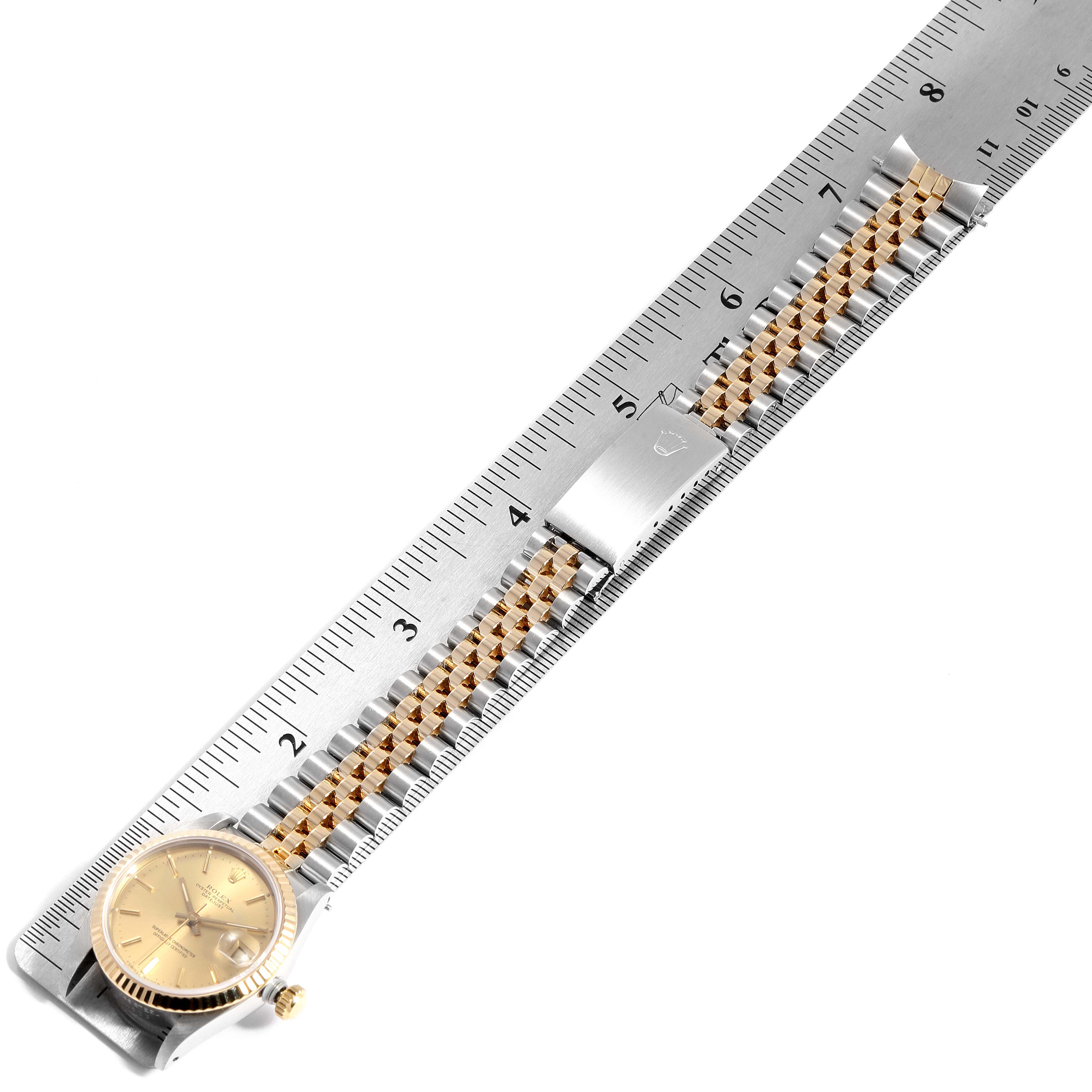 The Rolex Mid-Size 68273  Women
s Steel and Gold (two tone) Champagne Dial 68273  Women
s Steel and Gold (two tone) Champagne Dial model watch is shown from the top, displaying the face, bracelet, and clasp alongside a ruler.