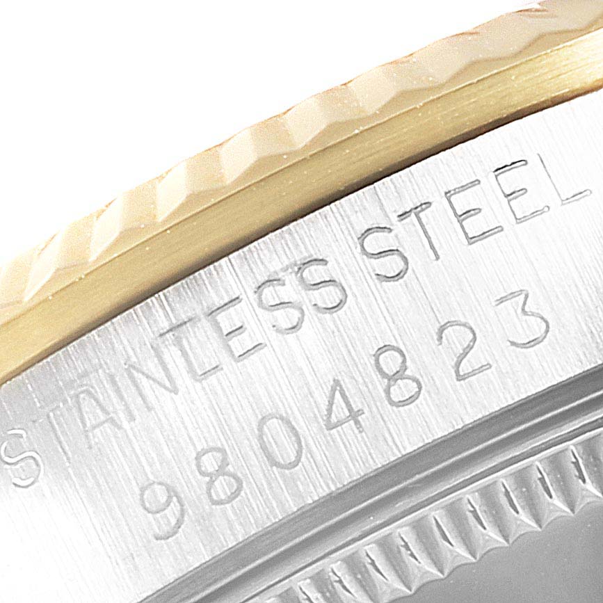 This image shows a close-up of the engraved serial number and the "STAINLESS STEEL" marking on a Rolex Mid-Size 68273  Women
s Steel and Gold (two tone) Champagne Dial 68273  Women
s Steel and Gold (two tone) Champagne Dial watch.