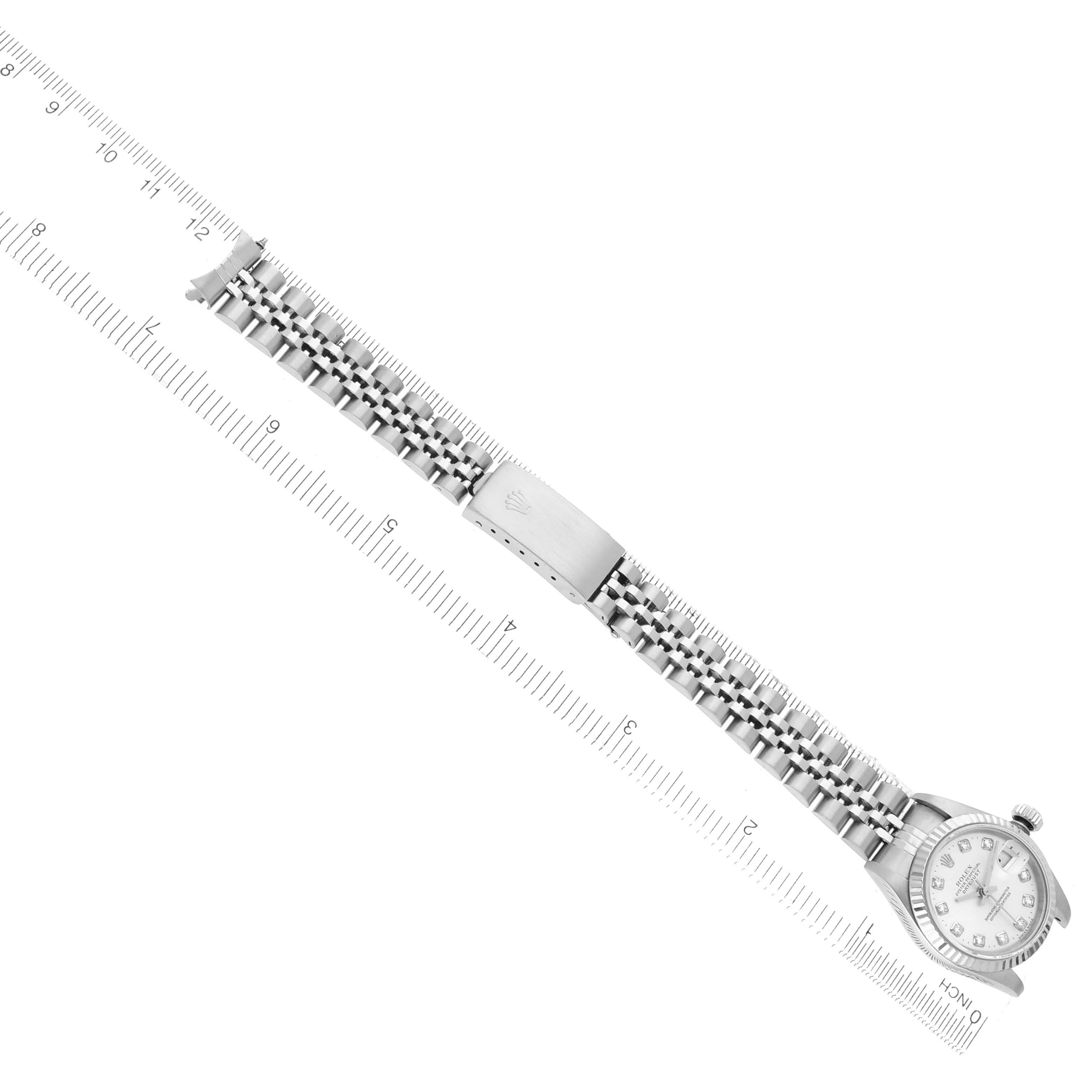 The Rolex Datejust 79174 Women
s Stainless Steel Silver Dial 79174 Women
s Stainless Steel Silver Dial watch is shown from an overhead angle, highlighting the bracelet and clasp alongside a ruler.