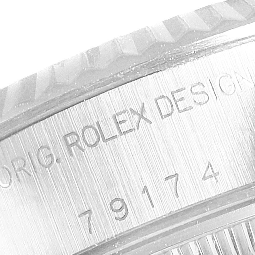 The image shows a close-up of the engraving on the case of the Rolex Datejust 79174  Women
s Stainless Steel Silver Dial 79174  Women
s Stainless Steel Silver Dial watch, including part of the fluted bezel.