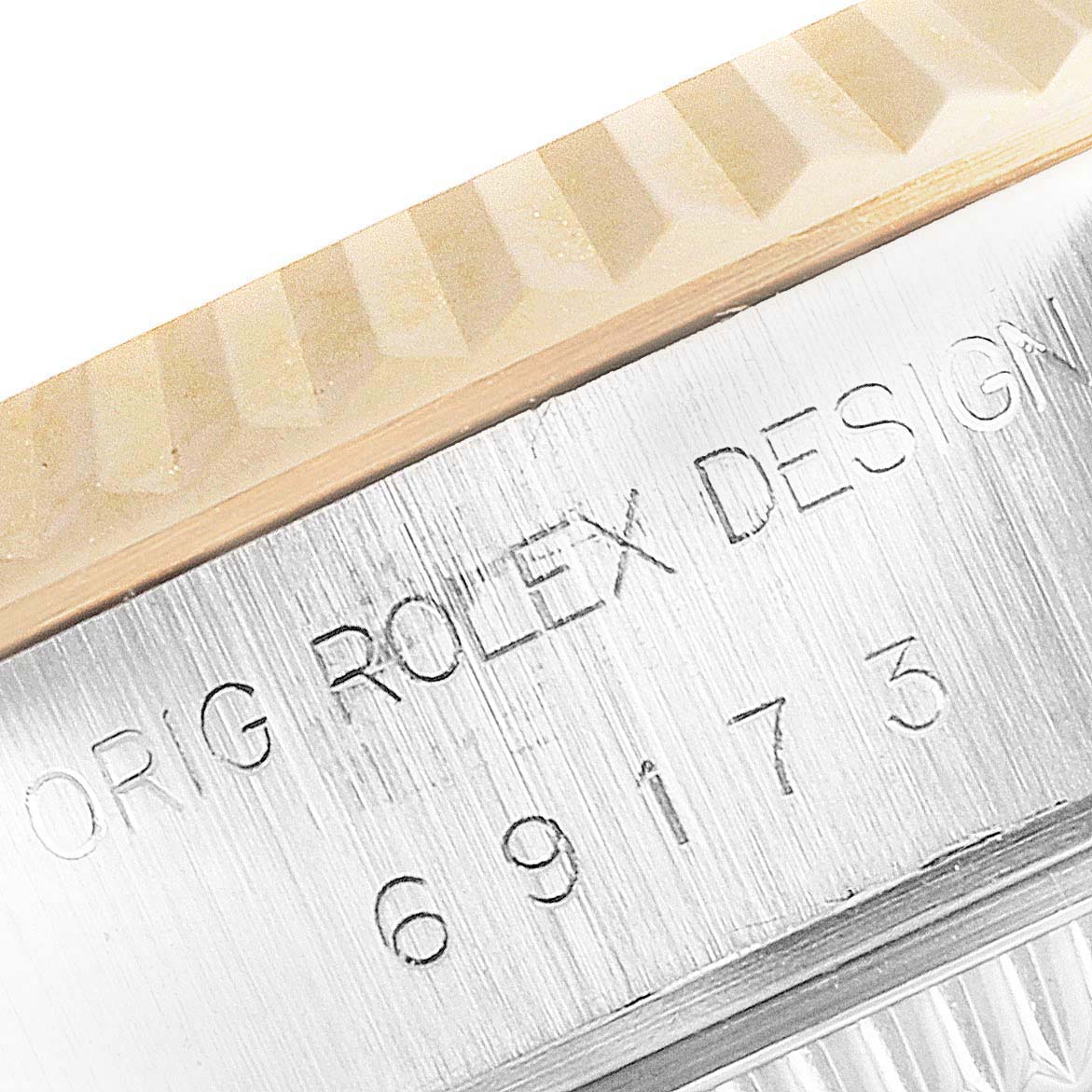 This image shows a close-up of the bezel and case of a Rolex Datejust 69173 Women's Stainless Steel Grey Dial 69173 Women's Stainless Steel Grey Dial model, highlighting the engraved text and fluted design.