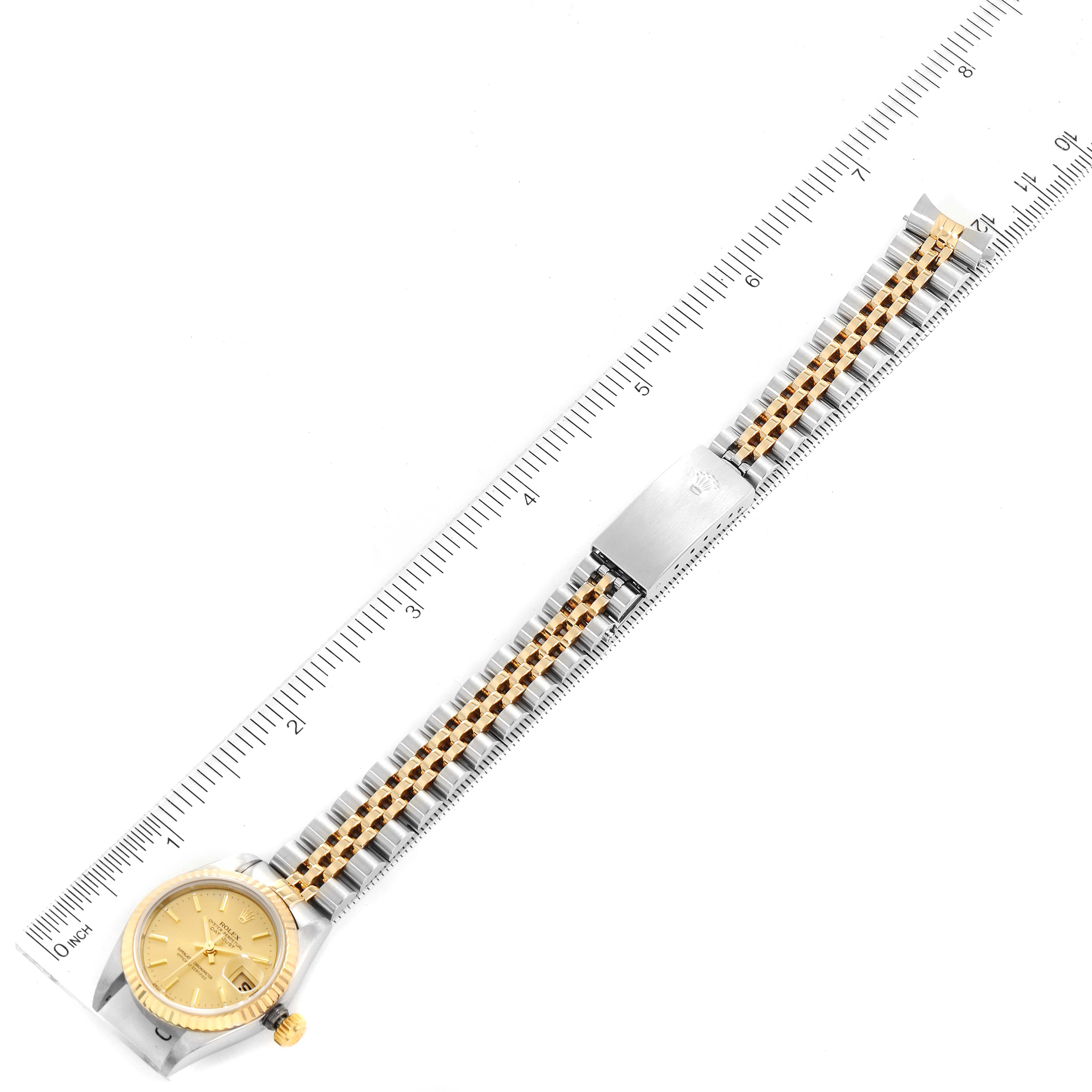 The image shows a full view of a Rolex Datejust 79173 Women
s Steel and Gold (two tone) Champagne Dial 79173 Women
s Steel and Gold (two tone) Champagne Dial watch, including the dial, bezel, crown, and two-tone bracelet, laid out flat.