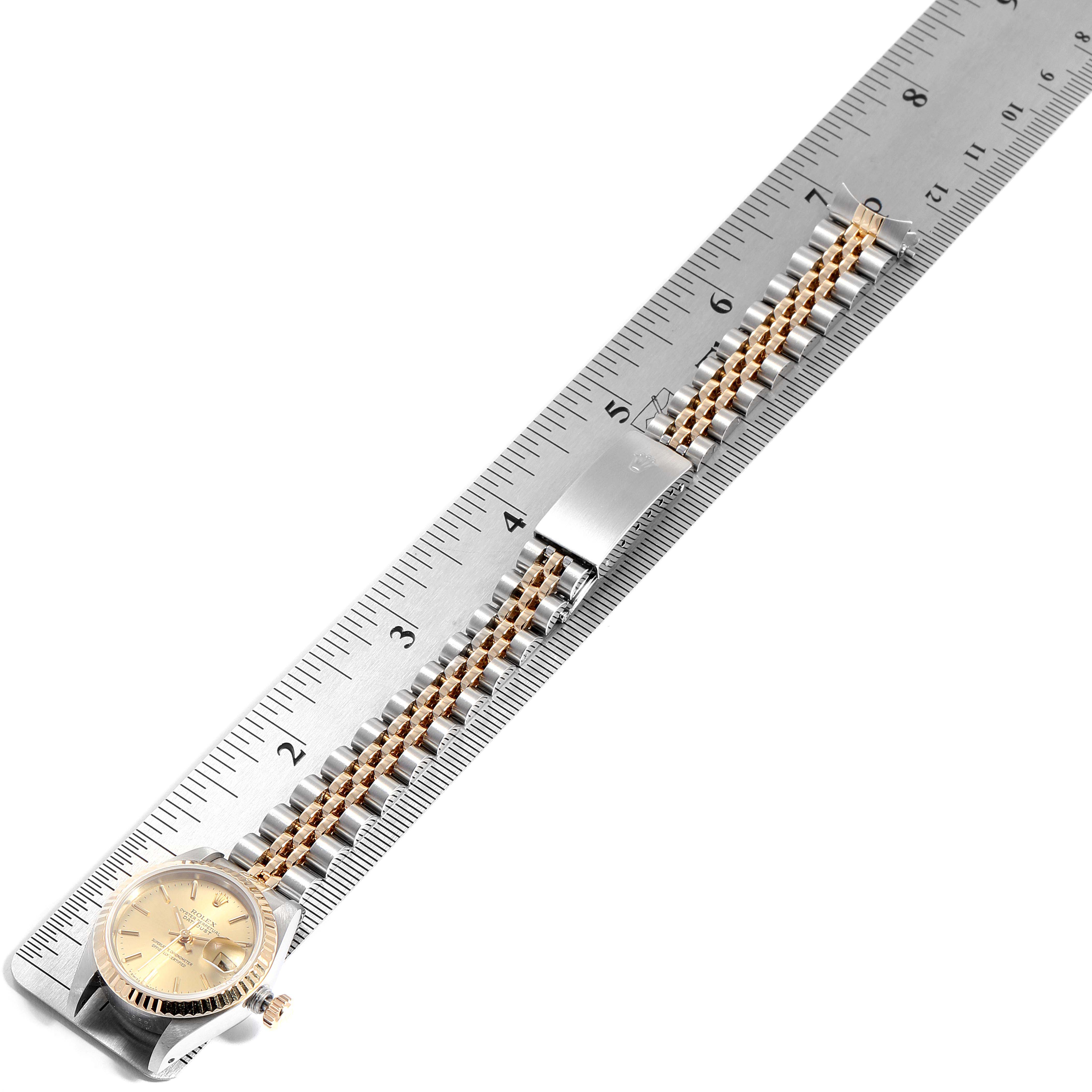 The image shows a Rolex Datejust 69173  Women
s Steel and Gold (two tone) Champagne Dial 69173  Women
s Steel and Gold (two tone) Champagne Dial watch placed diagonally on a ruler, displaying the face, crown, and part of the Jubilee bracelet.