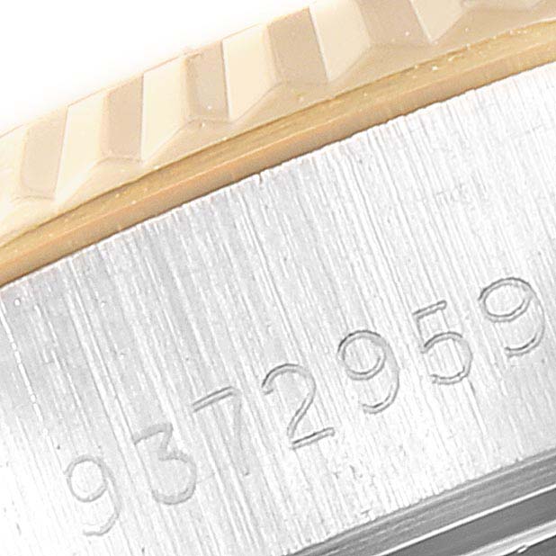 This image shows a close-up of the fluted bezel and partial serial number on a Rolex Datejust 69173  Women
s Steel and Gold (two tone) Champagne Dial 69173  Women
s Steel and Gold (two tone) Champagne Dial watch.