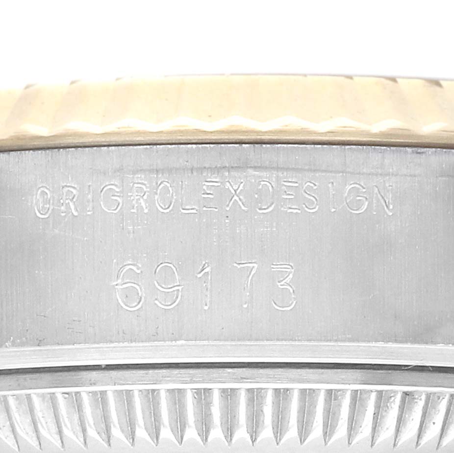 The image shows a close-up of the side of a Rolex Datejust 69173 Women
s Steel and Gold (two tone) Champagne Dial 69173 Women
s Steel and Gold (two tone) Champagne Dial watch case, displaying its engraved model number.