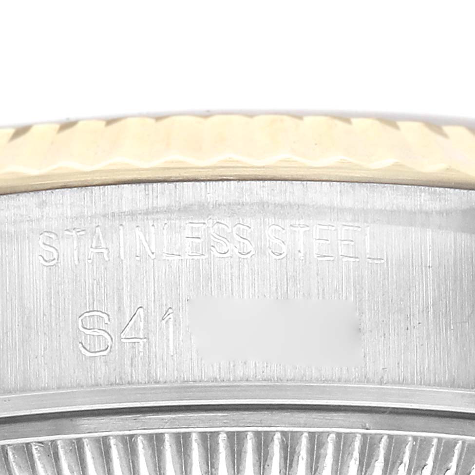 The image shows a close-up of the bezel and edge of the casing of a Rolex Datejust 69173 Women
s Steel and Gold (two tone) Champagne Dial 69173 Women
s Steel and Gold (two tone) Champagne Dial, highlighting the "STAINLESS STEEL" engraving.