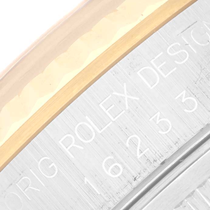 The image shows a close-up of the bezel and case side of a Rolex Datejust 16233 Men's Steel and Gold (two tone) Grey Dial 16233 Men's Steel and Gold (two tone) Grey Dial watch, highlighting engraved text and detailing.