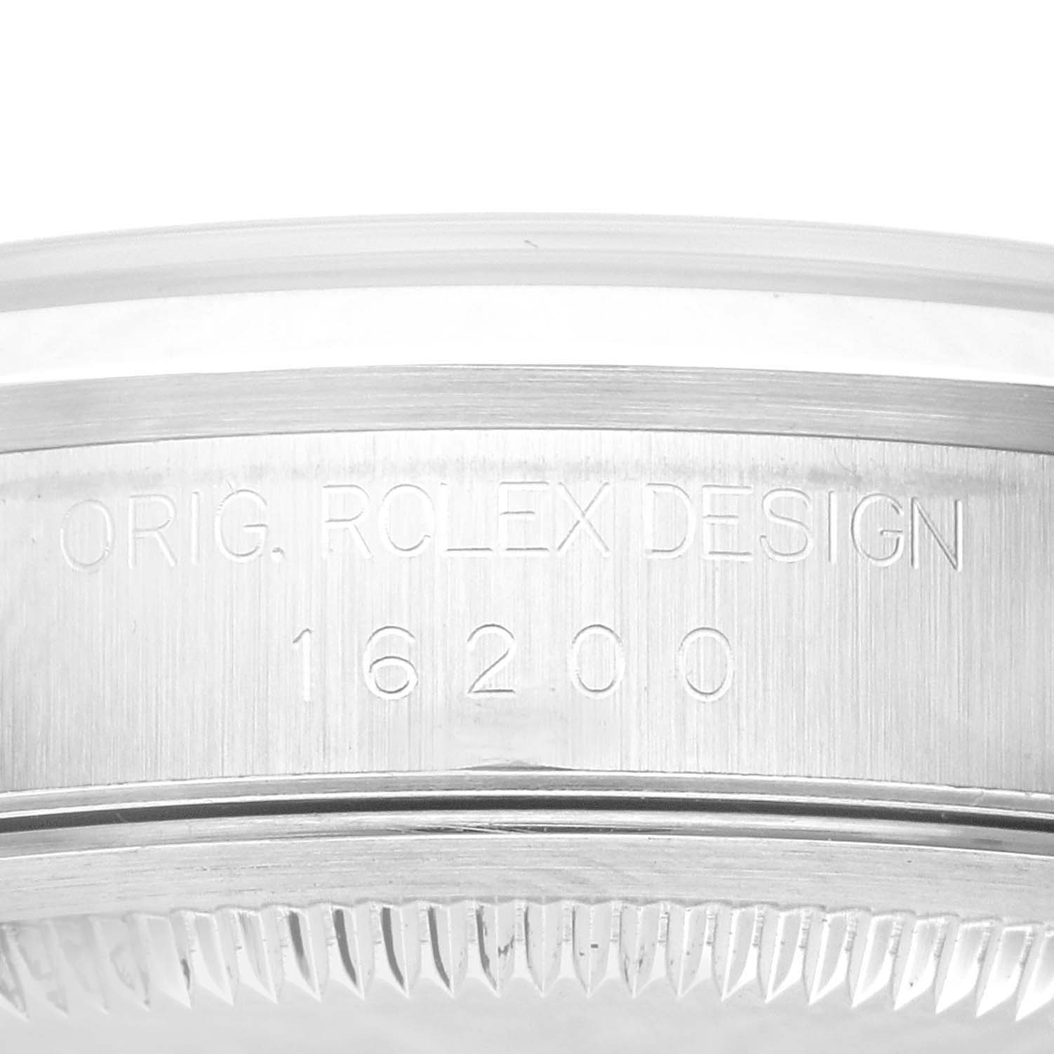 The image shows a close-up of the Rolex Datejust 16200 Men's Stainless Steel White Dial 16200 Men's Stainless Steel White Dial model 16200 watch case with "ORIG. ROLEX DESIGN" engraved.