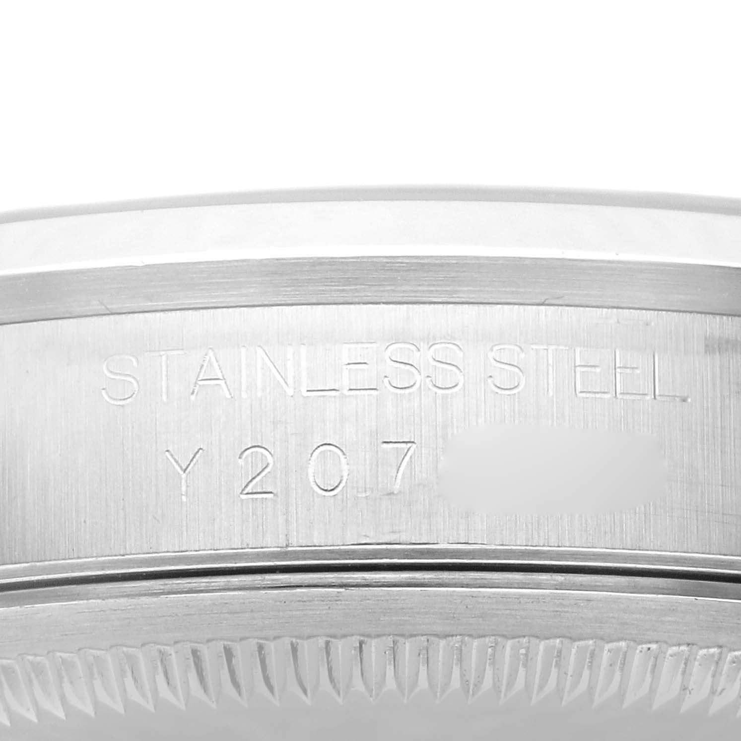 The image shows an angled close-up of the engraved case back of a Rolex Datejust 16200 Men's Stainless Steel White Dial 16200 Men's Stainless Steel White Dial with "Stainless Steel" and serial number partially visible.